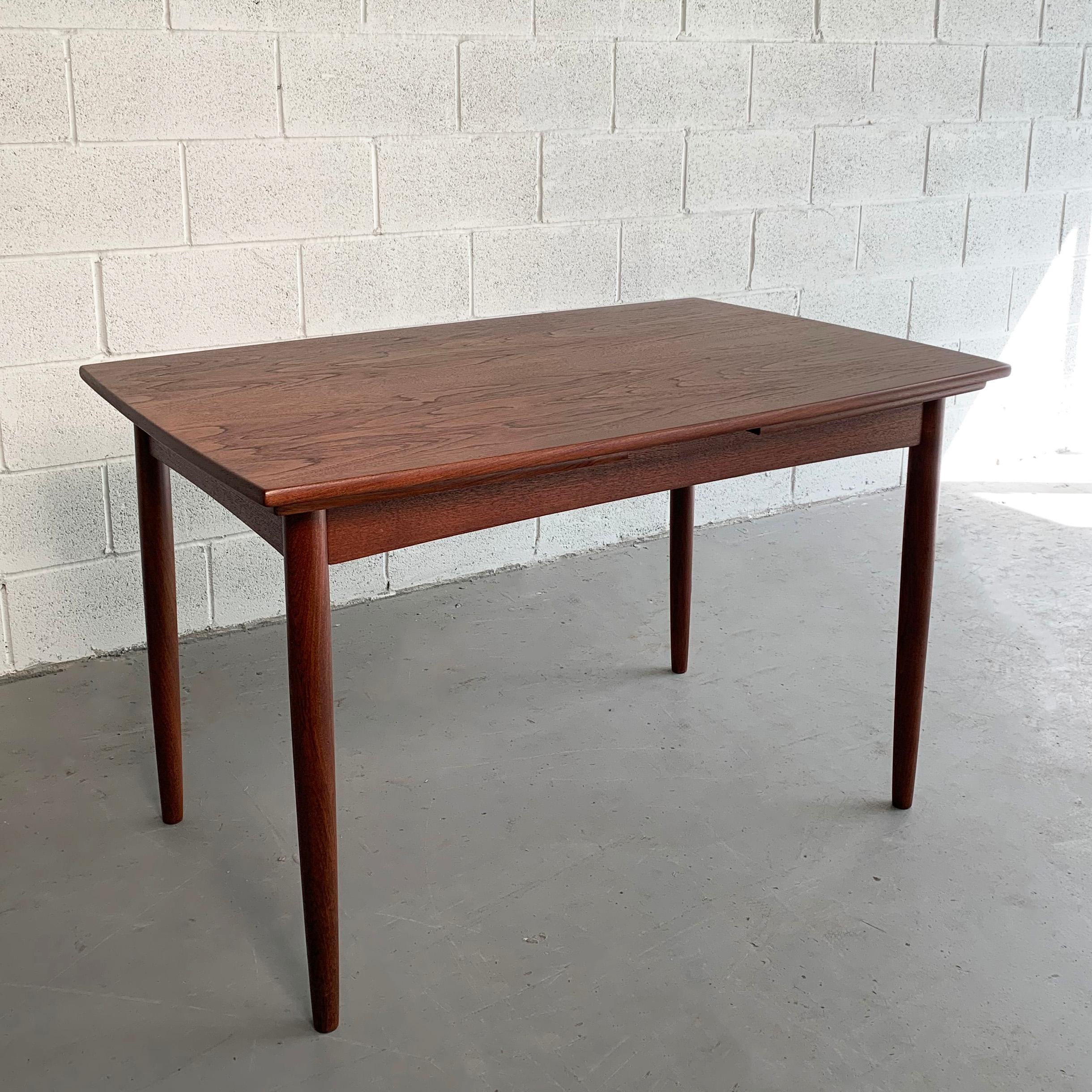 Danish modern, teak dining table features two 18 inch extension leaves that are stored underneath it's top that bring the table to 83 inches wide. The apron around the table is at 24 inches height.