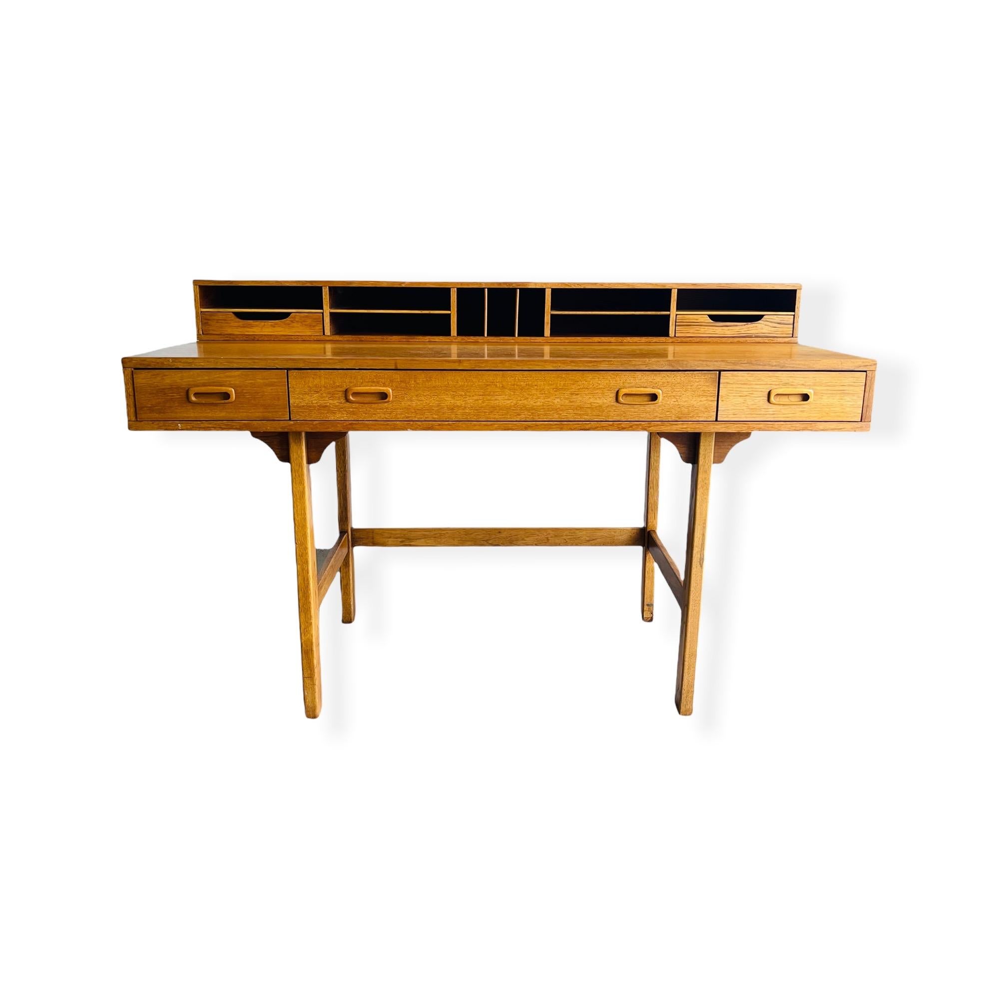 Beautiful Mid-Century Danish Modern teak desk by Peter Lovig Nielsen features a shelf that flips over creating a larger, flat work surface. With storage components on either side, this piece is ideal as a shared desk for home or office. The three