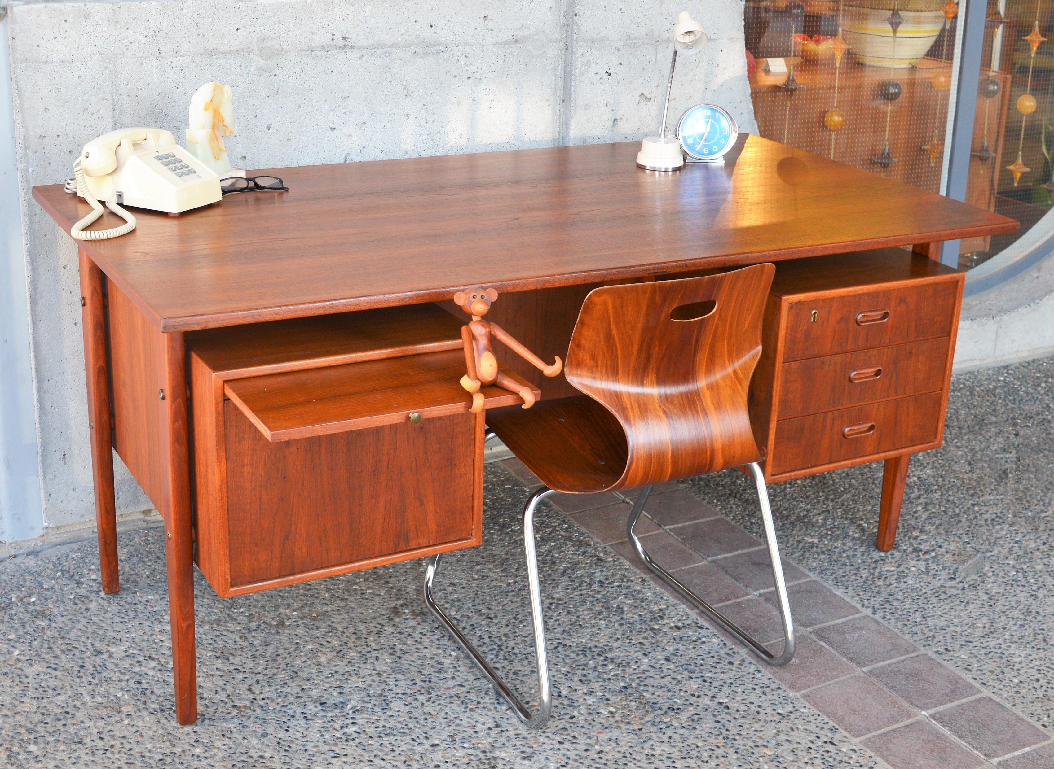 This beautiful Danish Modern quality teak executive desk has all the bells and whistles! Made of all wood, it features a floating top (cool to look right through it!), 4 drawers with beech drawer frame construction with dovetail joints - the one on