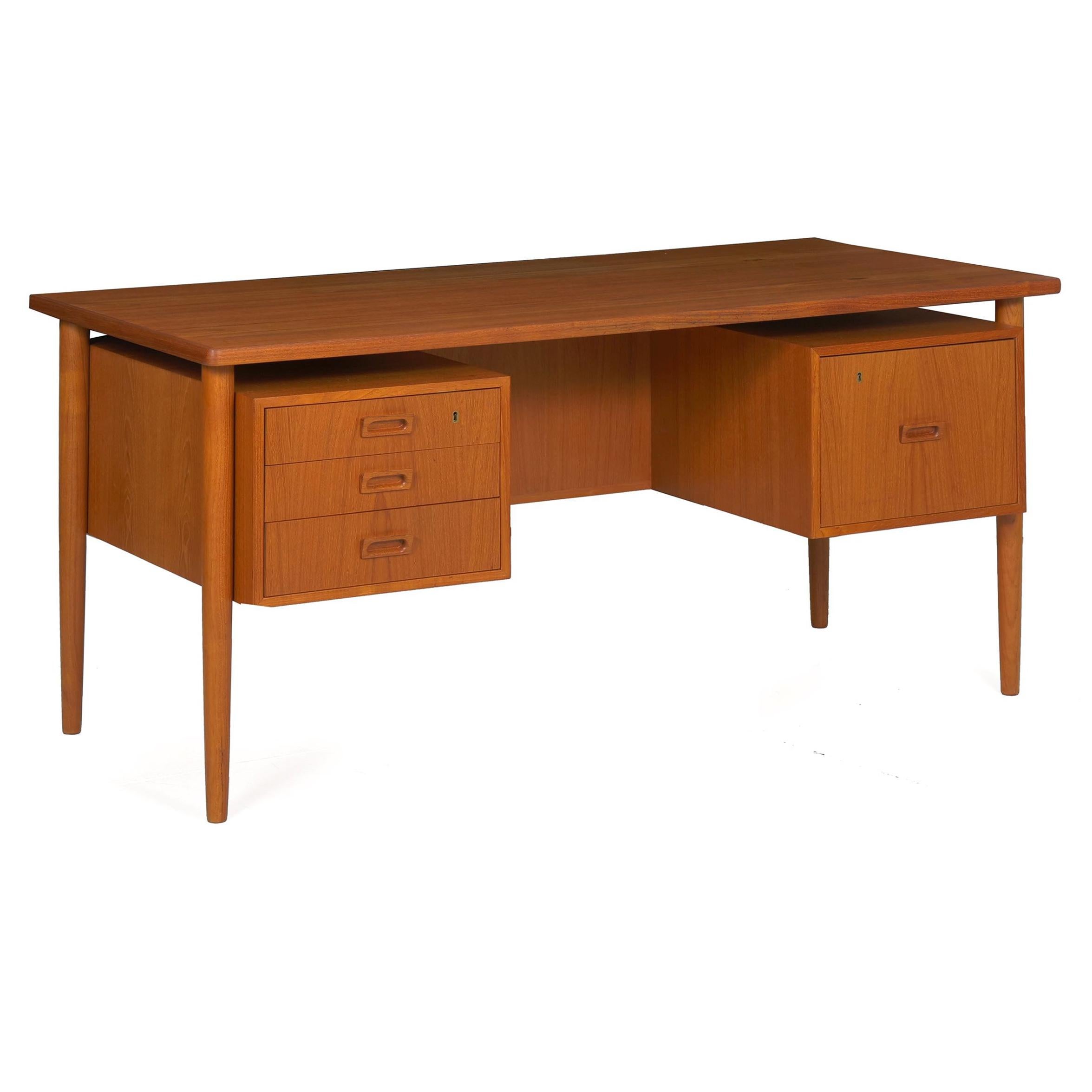A sleek and austere executive desk manufactured by Bornholm in Denmark during the 1960s, it is beautifully preserved and conserved in-house to present in excellent condition. With a stack of three drawers on the left and a single file cabinet on the