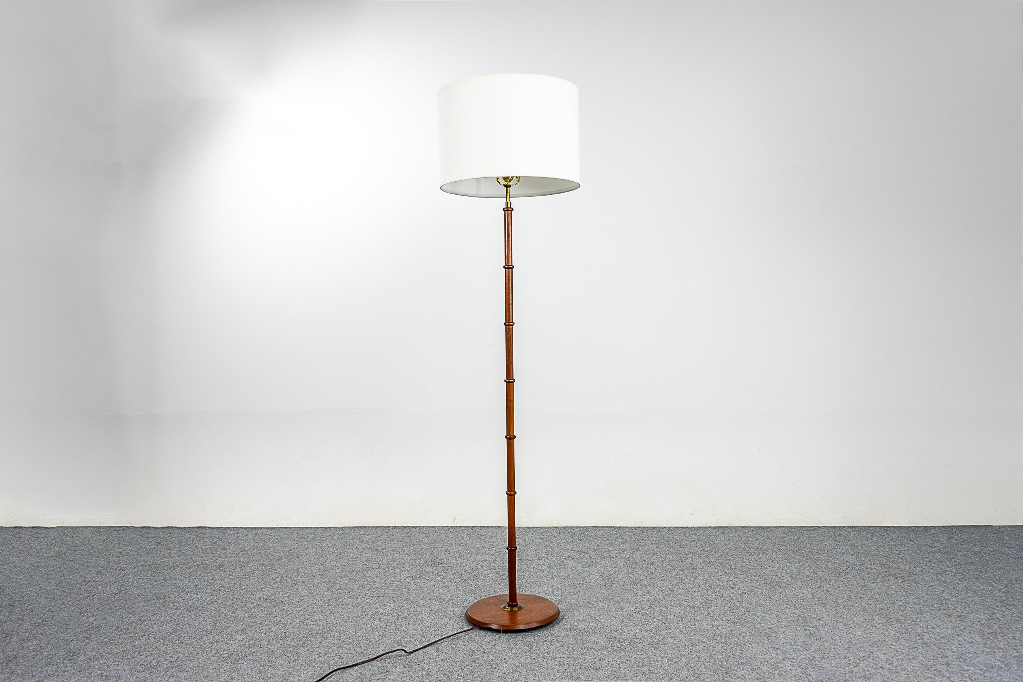 Teak Danish floor lamp, circa 1960's. Beautiful solid teak veneer construction with metal accents. Pristine custom fabric shade. New tri-light socket allows for 3 brightness levels, rewired for 110V.

Please inquire for international and remote