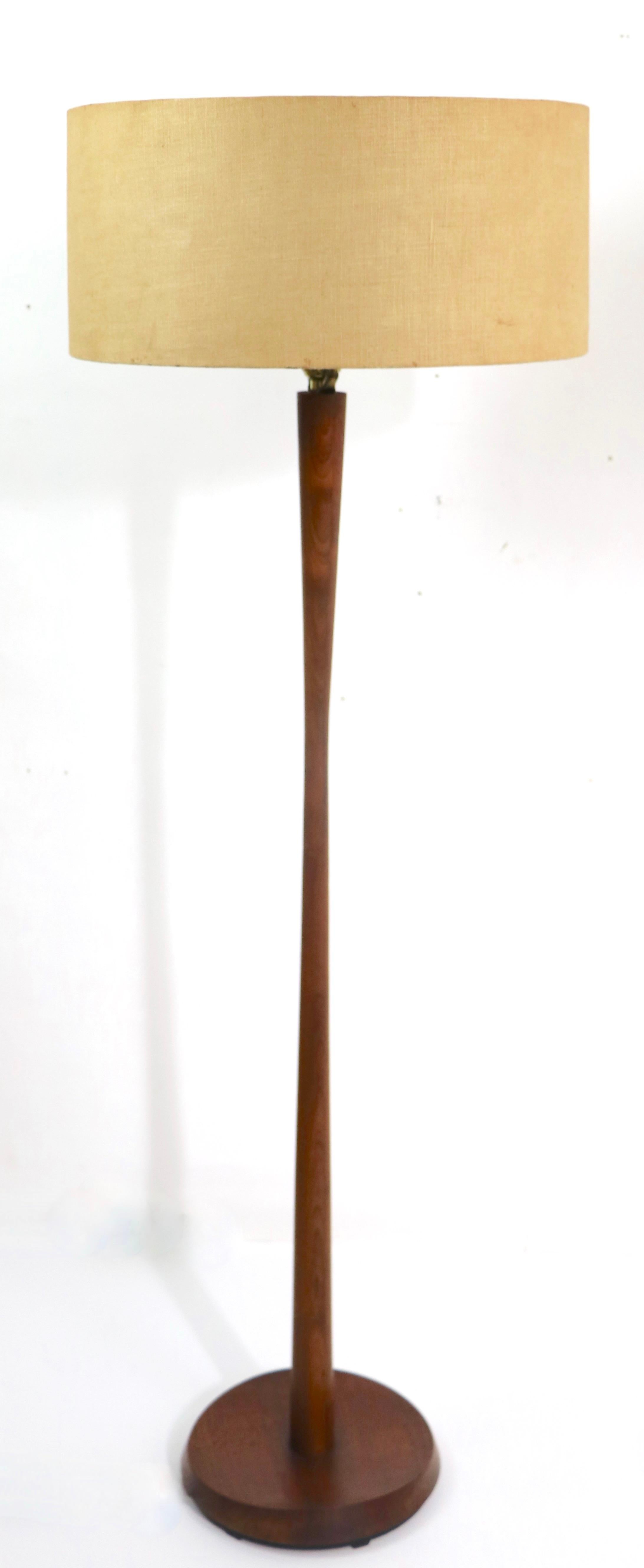 Elegant and sophisticated architectural floor lamp in solid teak, featuring an organic sculpted base, and curvaceous vertical standard. Original, clean and working condition, shade not included.
Measures: total H 53 x H to top of wood pole 43 inch.