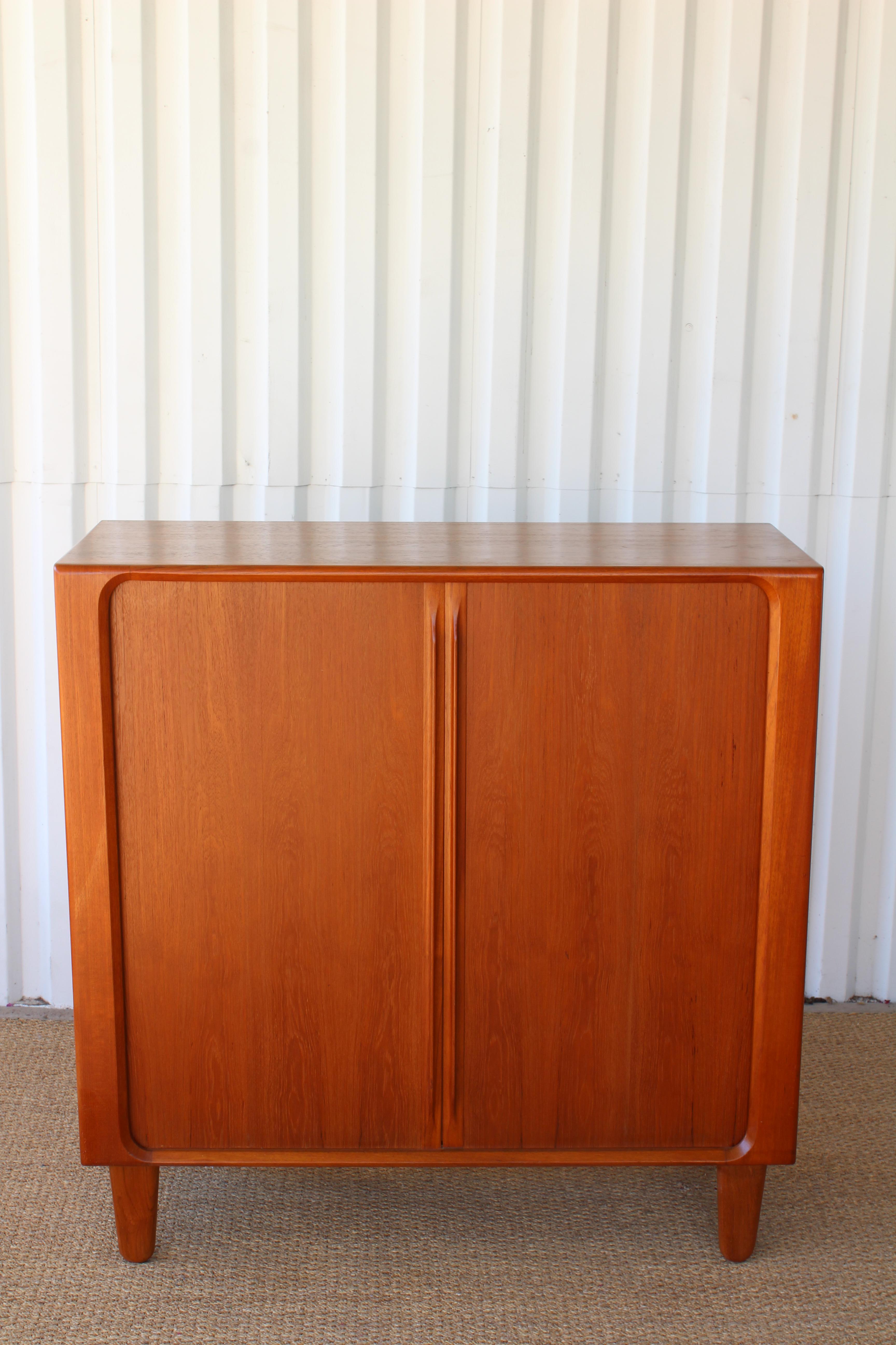 Danish modern solid teak highboy gentleman's dresser by Bernhard Pederson & Son from the 1960s. In excellent condition and recently refinished. Exceptional craftsmanship throughout. Features tambour sliding doors, dovetailed drawers, sculpted teak