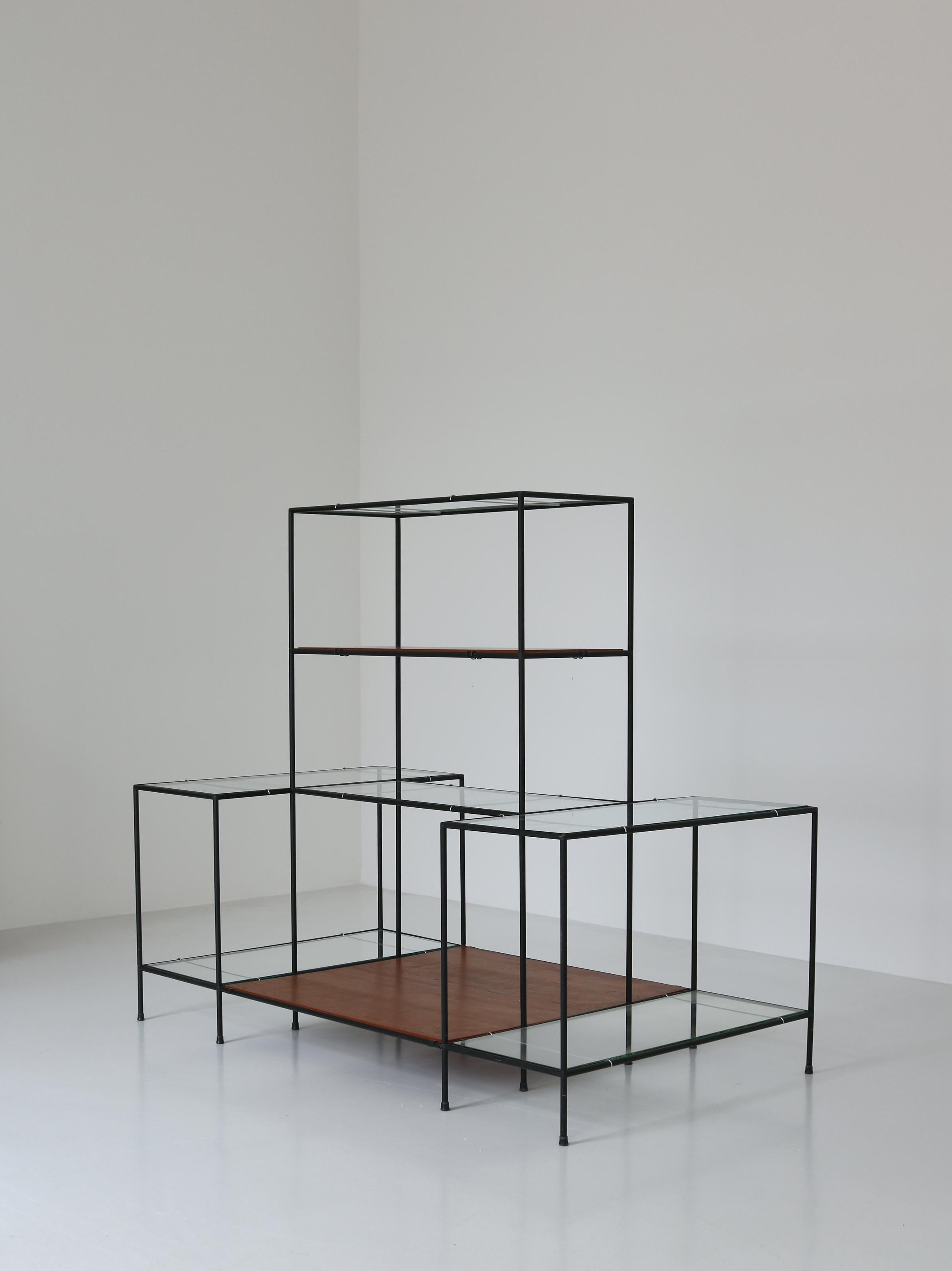 Ingenious minimalist shelving or display unit SYSTEM ABSTRACTA designed by Poul Cadovius, Denmark, in the 1960s. The system consists of black metal tubes with patented connectors, floating teak wood and thick glass shelves. The minimalistic and