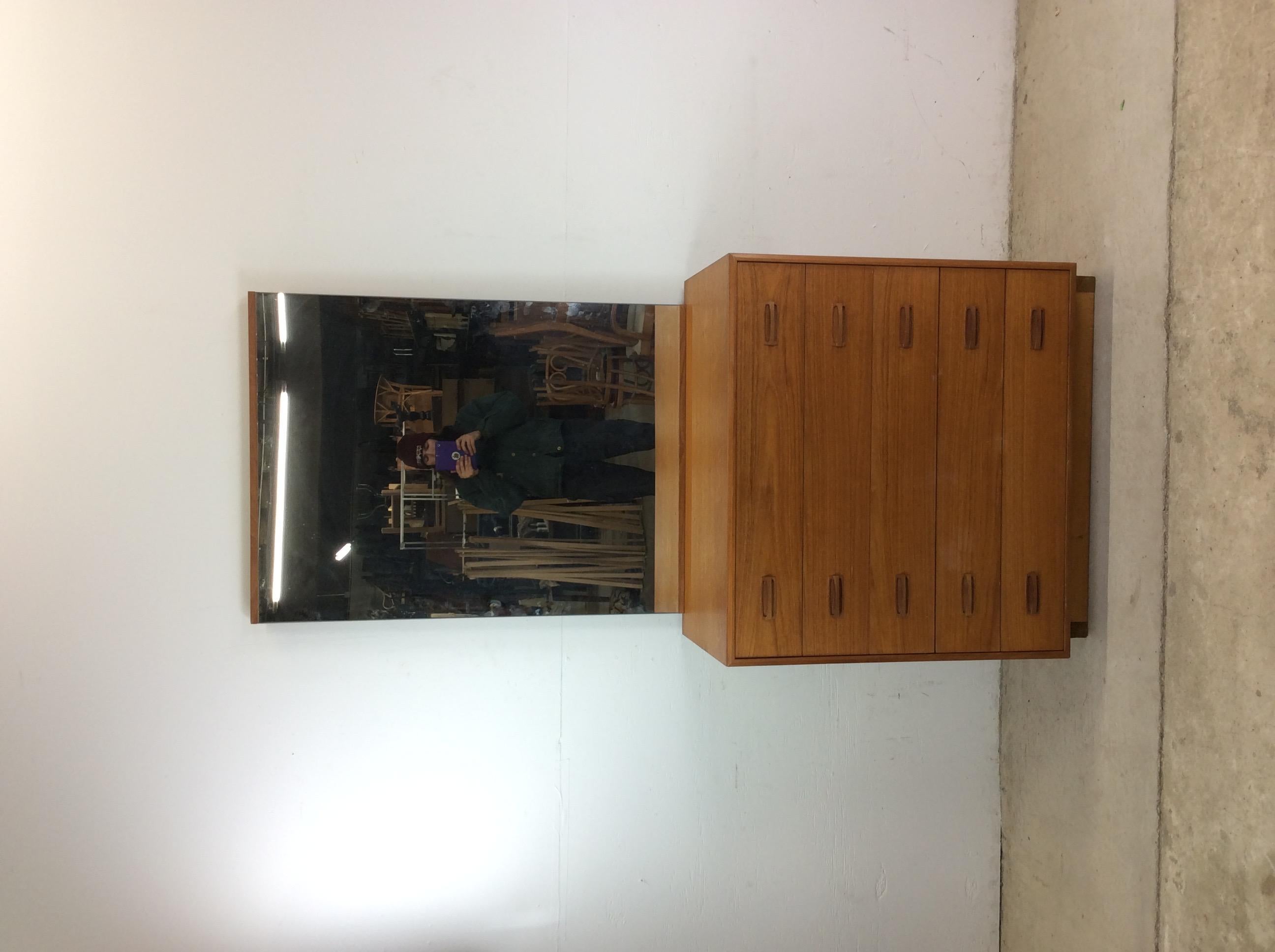 This Danish modern highboy dresser with mounted mirror features pressed wood construction, five dovetail drawers with wood pulls, unique frameless mounted mirror and plinth base.  Listing height is combined dresser & mirror height.   Dresser height: