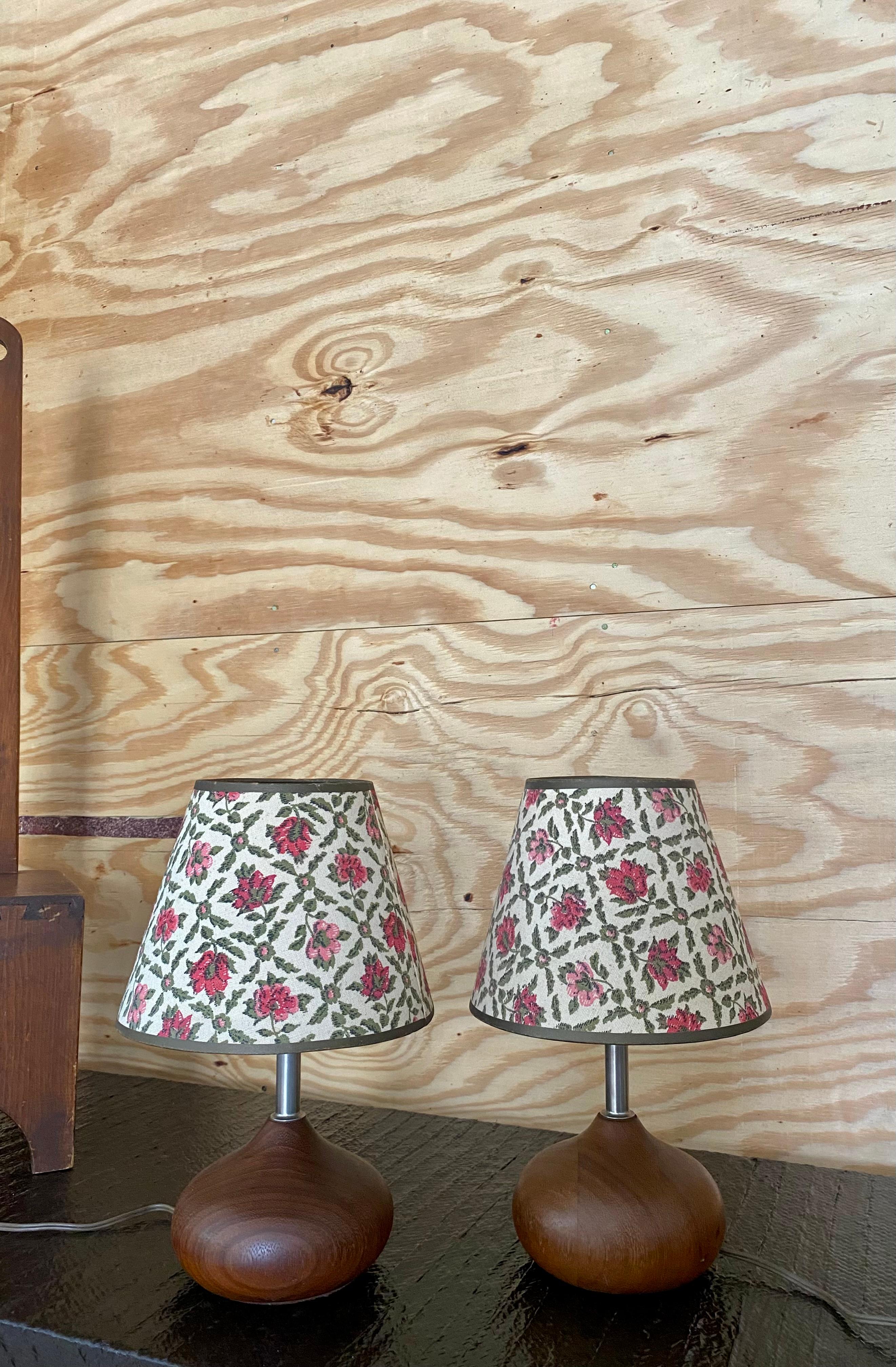 Charmante paire de lampes à pied en teck tourné, avec des abat-jours en lin parfaitement patinés, ornés de roses légèrement décolorées. 

Un mélange 