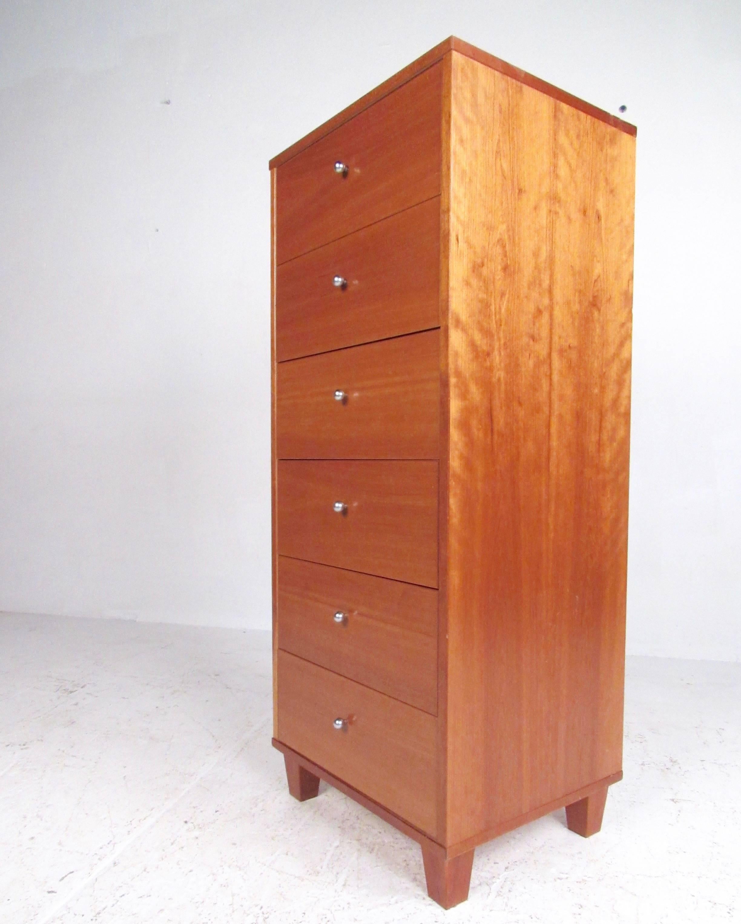 This stylish modern lingerie chest features Danish teak finish, and six spacious drawers for versatile bedroom storage. Steel ball drawer pulls add to the unique Scandinavian Modern appeal of this tall chest of drawers. Please confirm item location