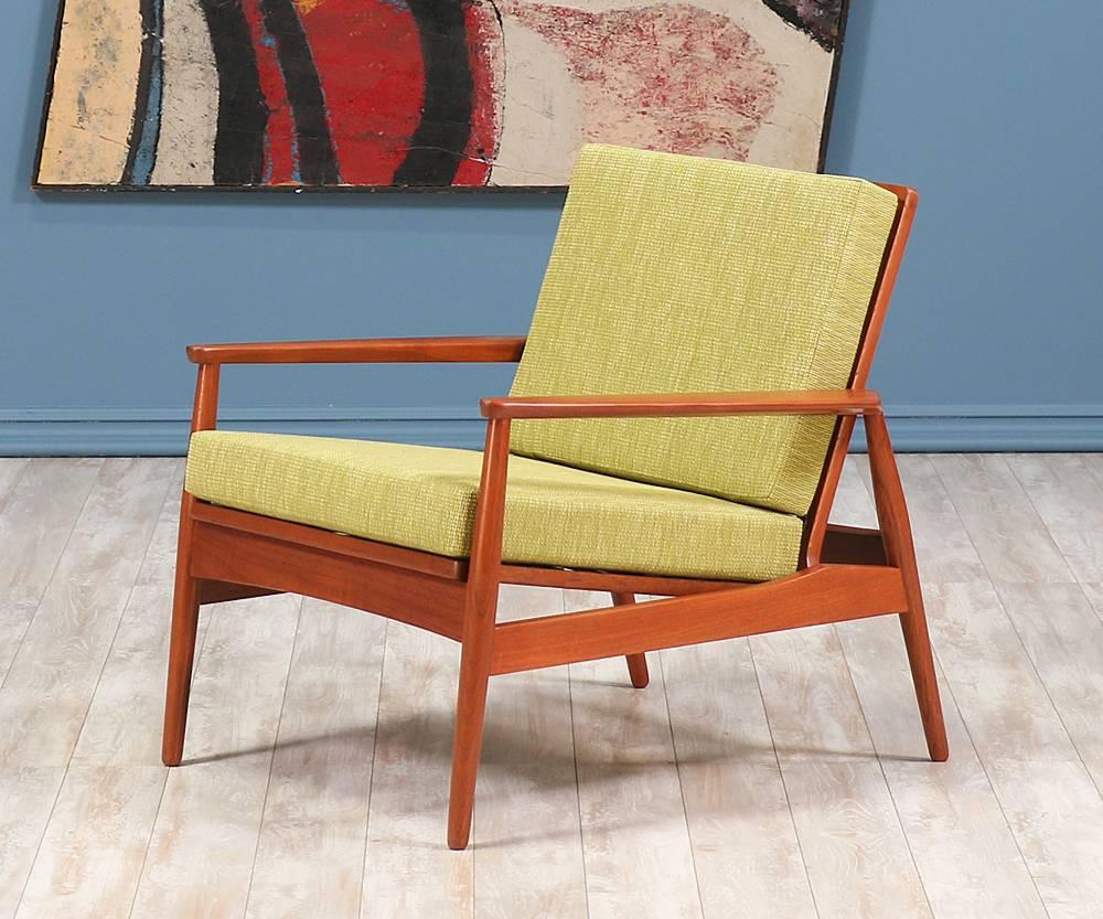 Danish modern teak lounge chair designed and manufactured in Denmark circa 1950's. This sleek and stylish design features an open linear back with vinyl covered springs for comfort and support. The seat has been revamped with new support straps for