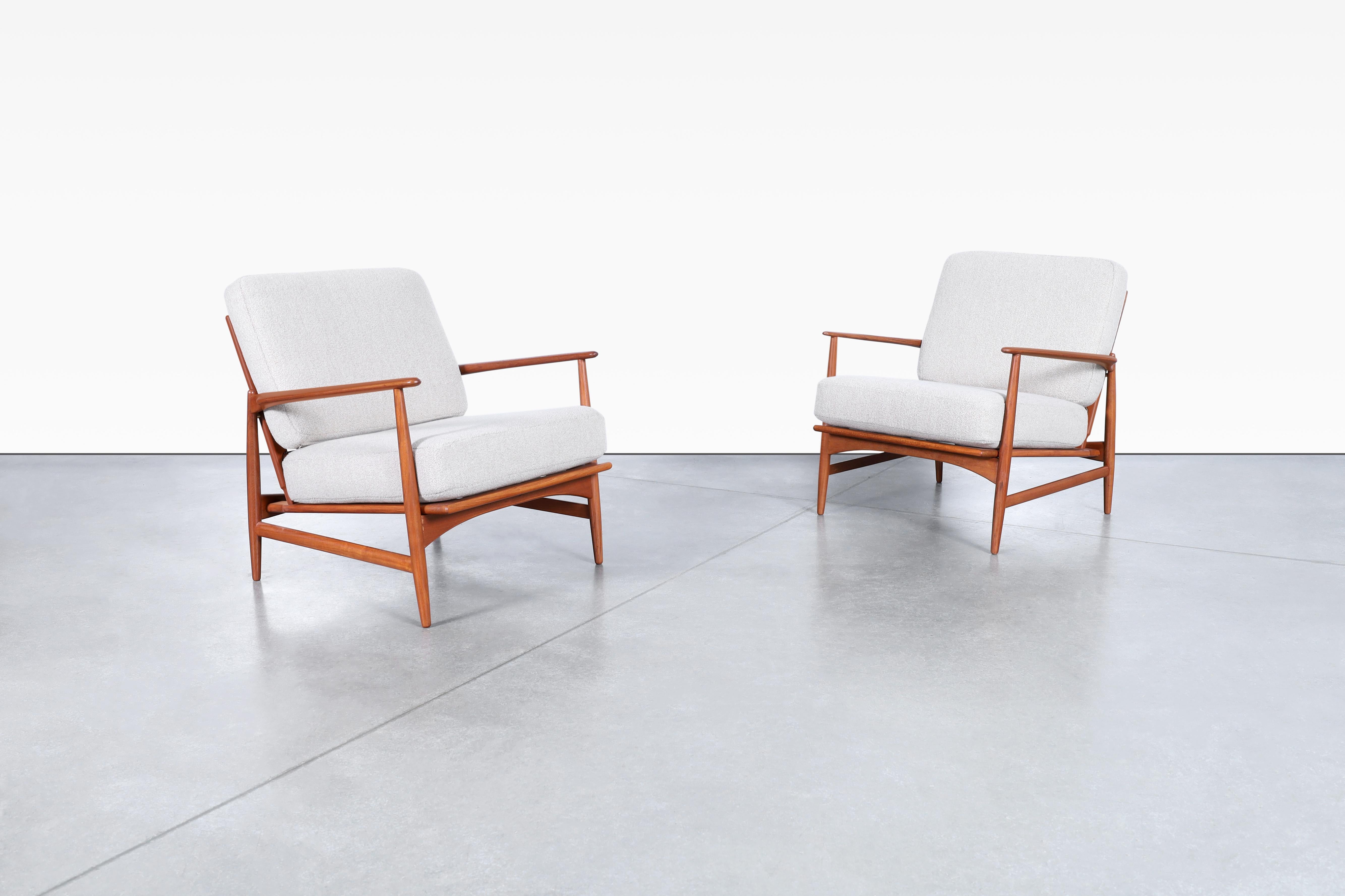 Amazing Danish modern teak lounge chairs designed by Ib Kofod Larsen for Selig in Denmark, circa 1960s. These chairs are truly stunning! The solid handcrafted teak frame is expertly crafted to create a sleek profile that will elevate any room. The