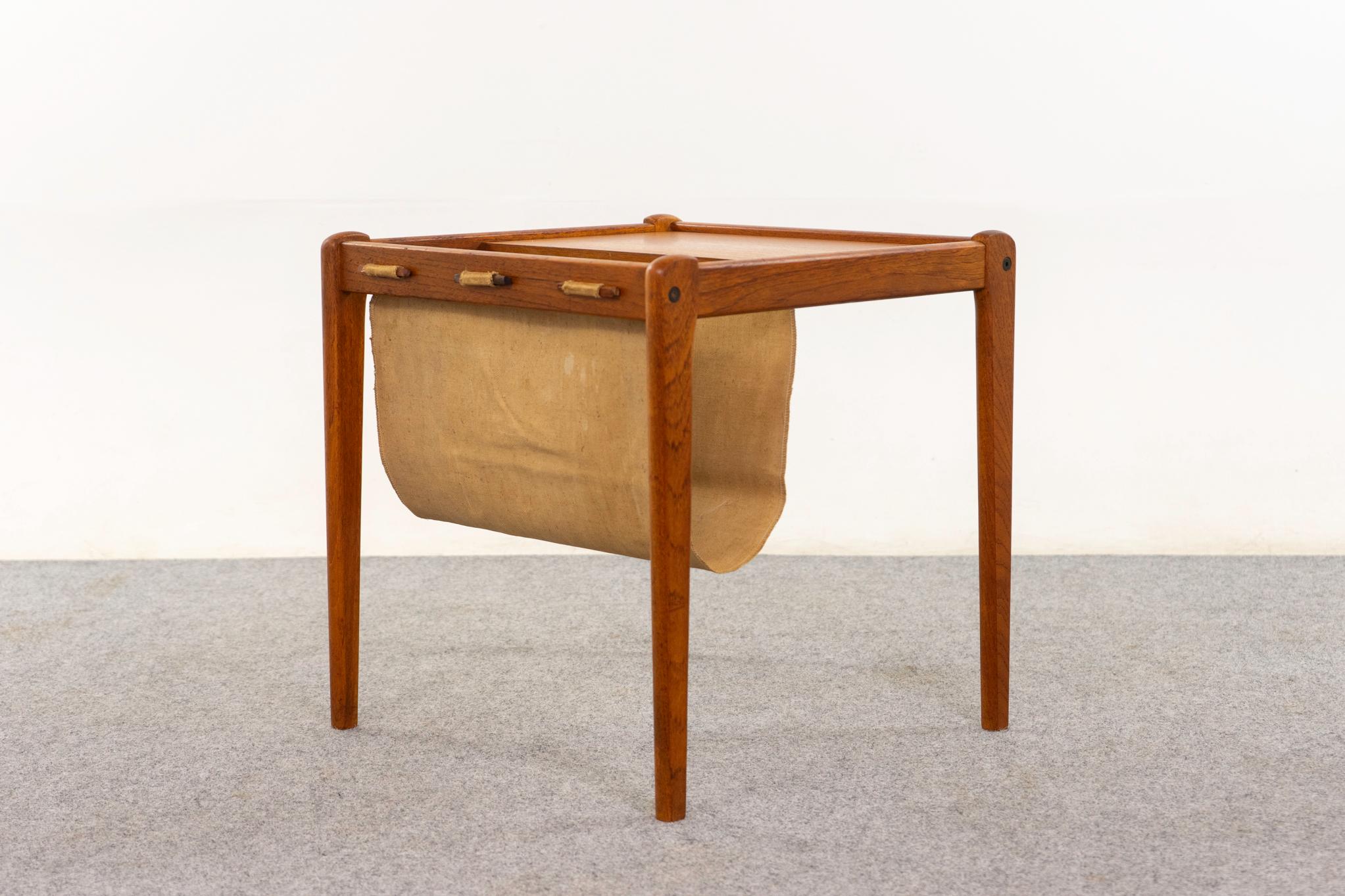 Teak Danish magazine/side table by Spottrup, circa 1960s. Charming table with bookmatched veneer top, solid legs, and a canvas sling magazine holder!
