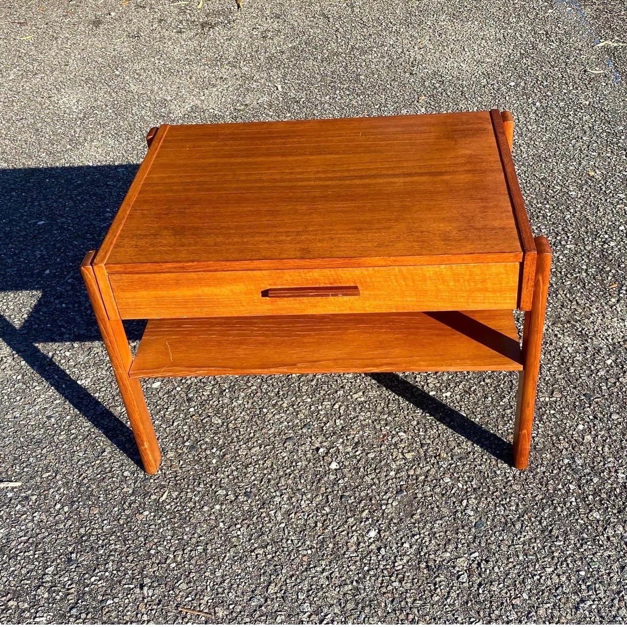 A sweet Danish teak side table with drawer and lower shelf. In very good vintage condition with a few small light scratches. Made in Denmark by Graebel.