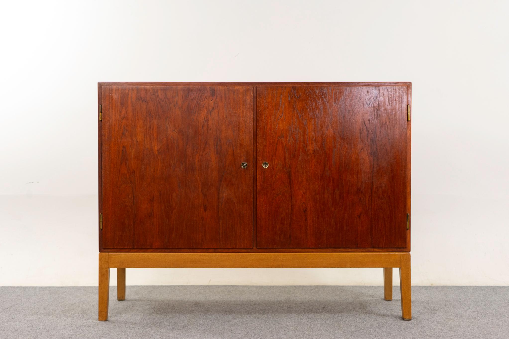 Mobile danese in teak e quercia di Borg Mogensen, anni '50 circa. Doppie porte con serratura, eccezionale impiallacciatura in teak abbinata al libro e base in rovere massiccio a contrasto. Scaffali e cassetti regolabili.

Oggetto non restaurato con