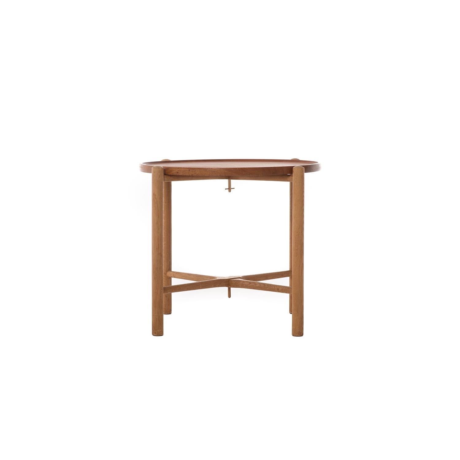 This Danish modern original table is made from solid old growth teak and white oak. The tabletop is reversible and can be used as a tray, the base folds in two. Portable and easily storable, and notably beautiful as well! Hans J. Wegner drives it
