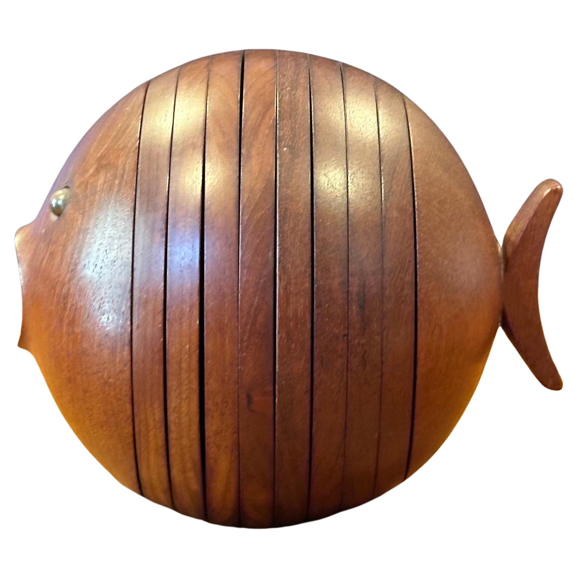 A classic and very hard to find Danish modern teak puffer fish coaster set by Ernst Henriksen, circa 1960s. The set has eight coaster sections that are secured via brass eyes (poles); the piece works as a functional coater set or a decorative piece