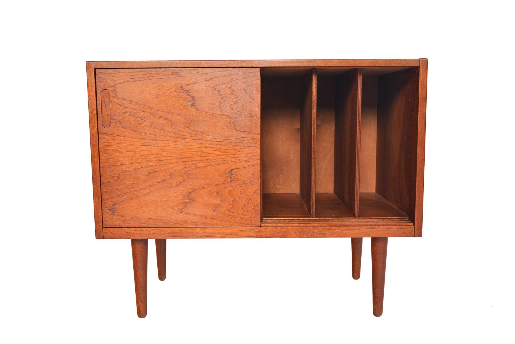 This Danish modern midcentury small record cabinet is crafted with stunning bookmatched wood grain on the doors. They open to reveal four record dividers. In excellent original condition.

   