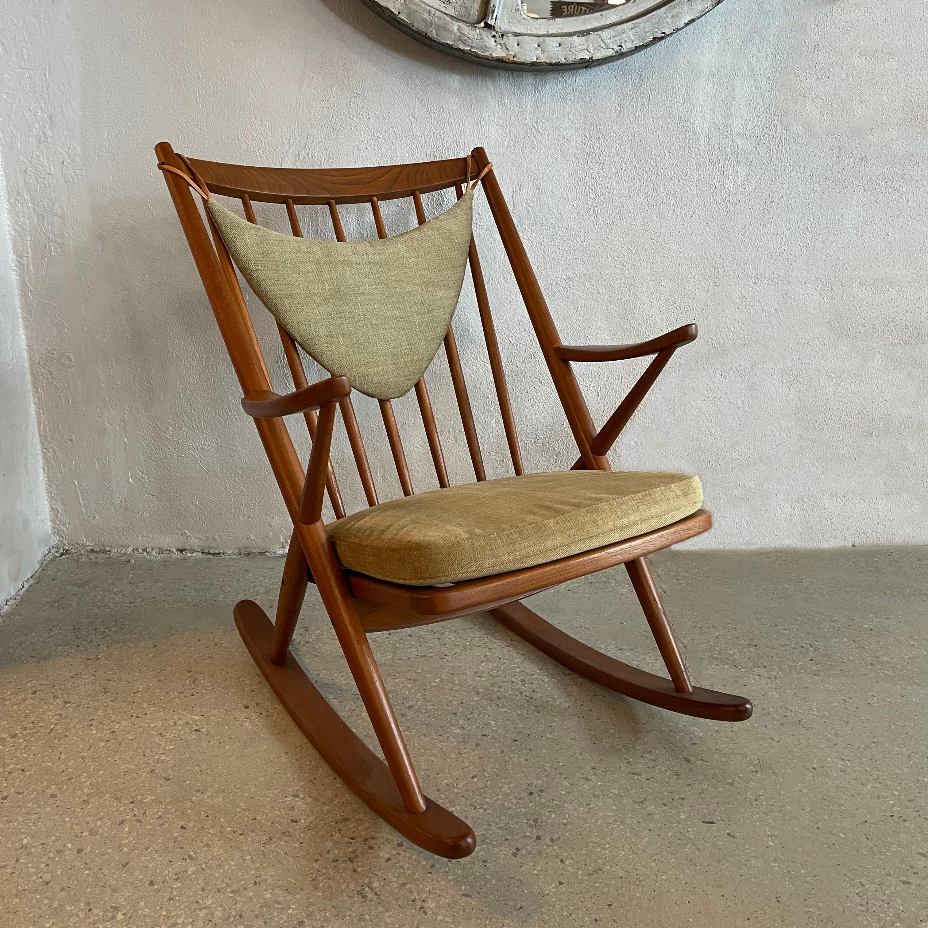 Iconic, Danish Modern rocking chair designed by Frank Reenskaug for Bramin Mobler features a refinished, solid teak wood frame with spindle back. The cushions have been newly upholstered in a soft oatmeal brushed cotton tweed, following the original