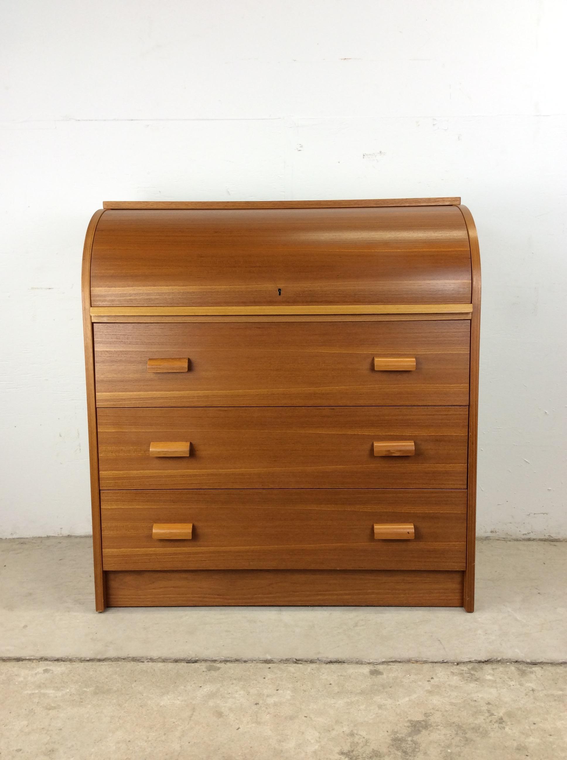 This Danish modern writing desk features pressed wood construction, beautiful teak veneer, roll top design with lock, expanding writing service that pulls out for additional surface area, four drawers with bent wood pulls.   Draw leaf desk expands