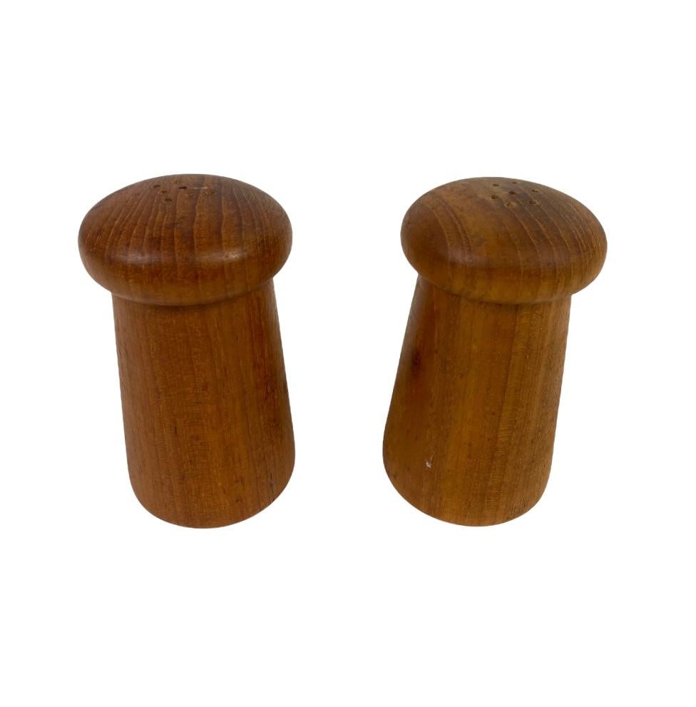 Handsome minimalist pair of salt and pepper shakers. Executed in teak wood with warm tones and attractive grains. In good condition with even color and no major wear.