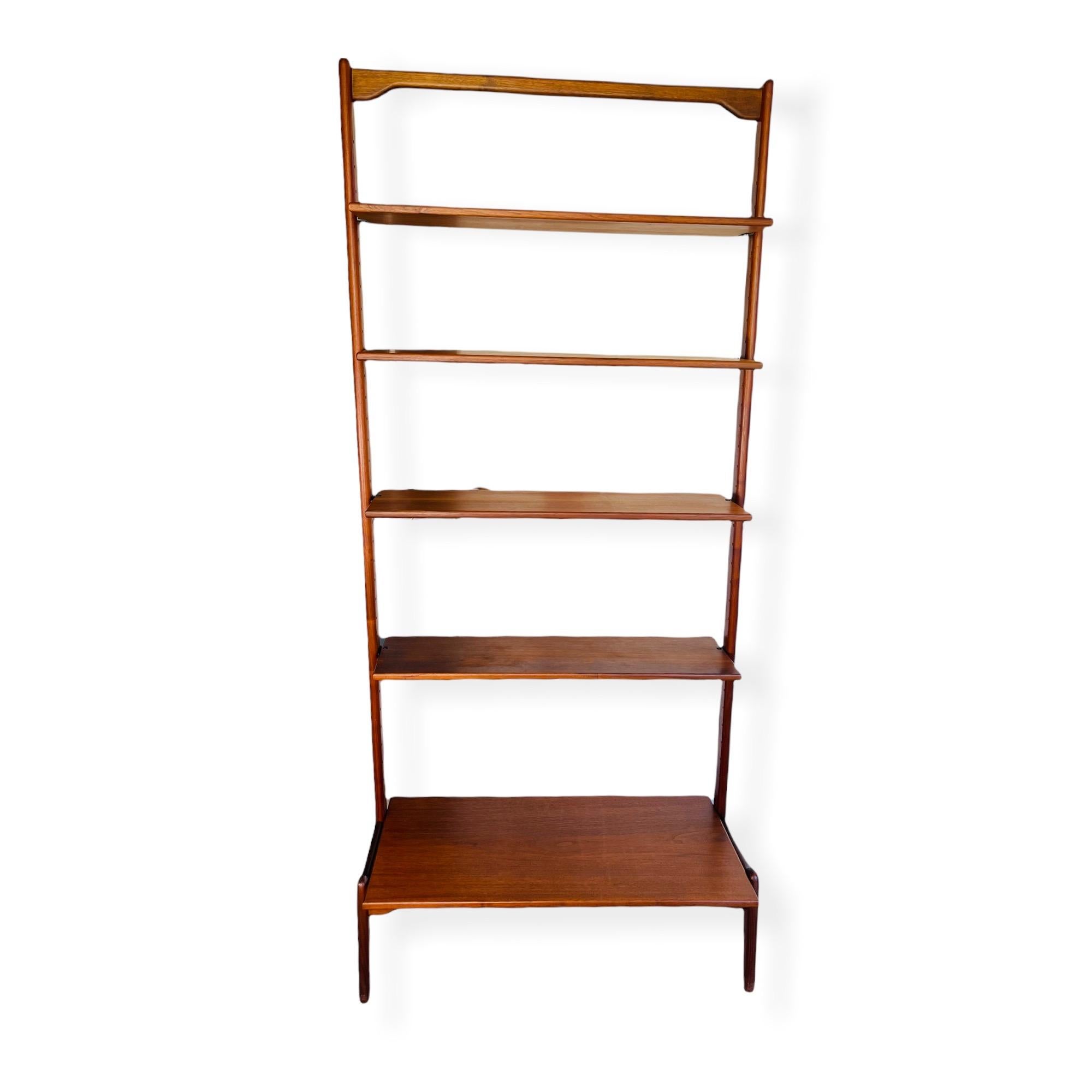 Stunning Danish modern sculptural teak bookshelf designed by Erik Buch of Denmark. This unique bookshelf features adjustable shelves and comes apart in pieces. Each shelf is marked “Made In Denmark”. This bookshelf is in good vintage condition with