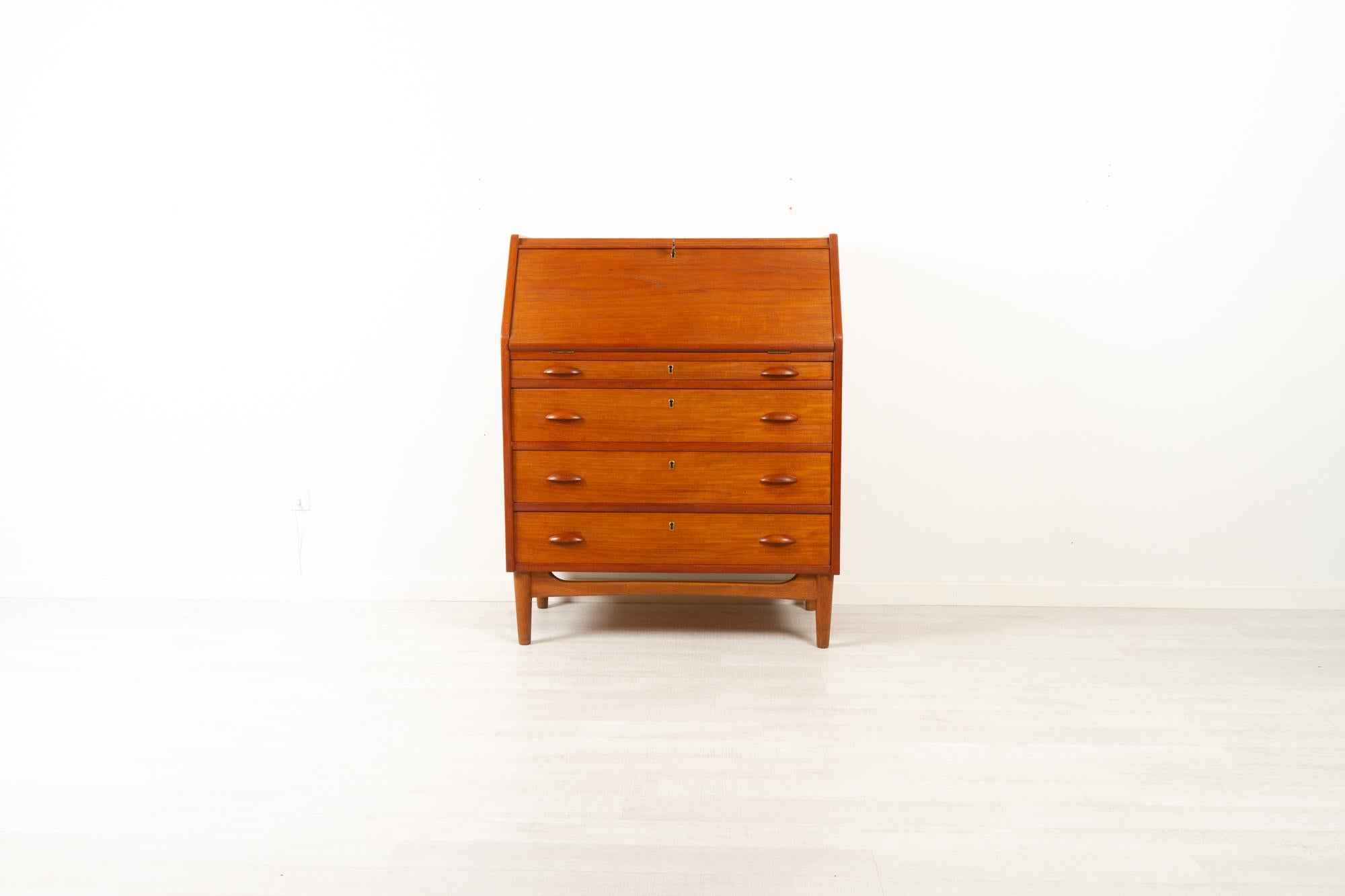 Danish modern teak secretaire, 1960s
Very versatile piece of Mid-Century Modern Danish design, elegant and suitable for many uses. 
This secretary has a lower section with four wide drawers, all with locks. The top section is fitted with a