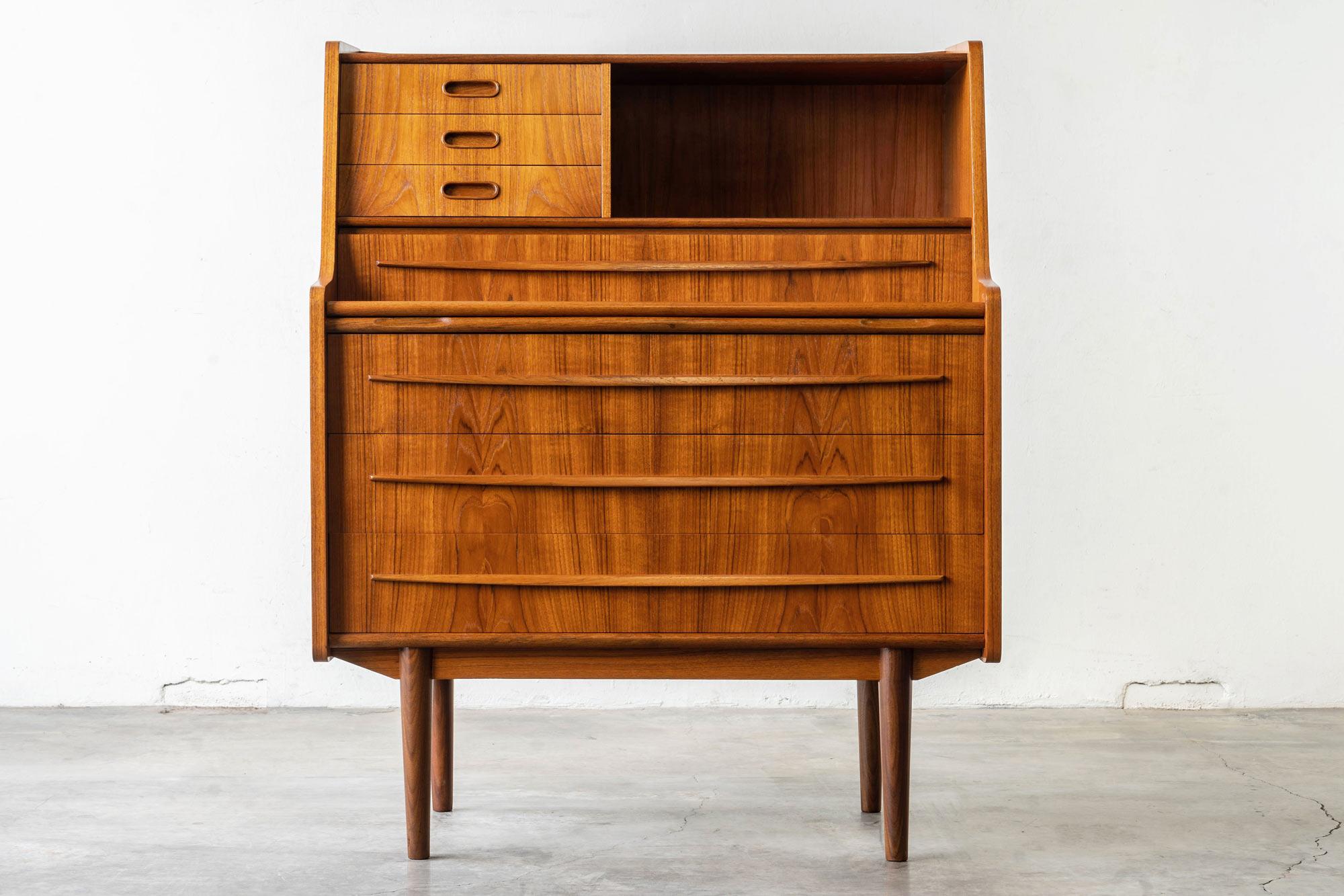 This incredible Danish modern teak vanity secretary desk hails straight from the 1960s. Manufactured by Gunnar Falsig.

Features:

• Beautiful, insane, rich, teak wood-grain
• Pull out vanity with original robin's egg blue interior and