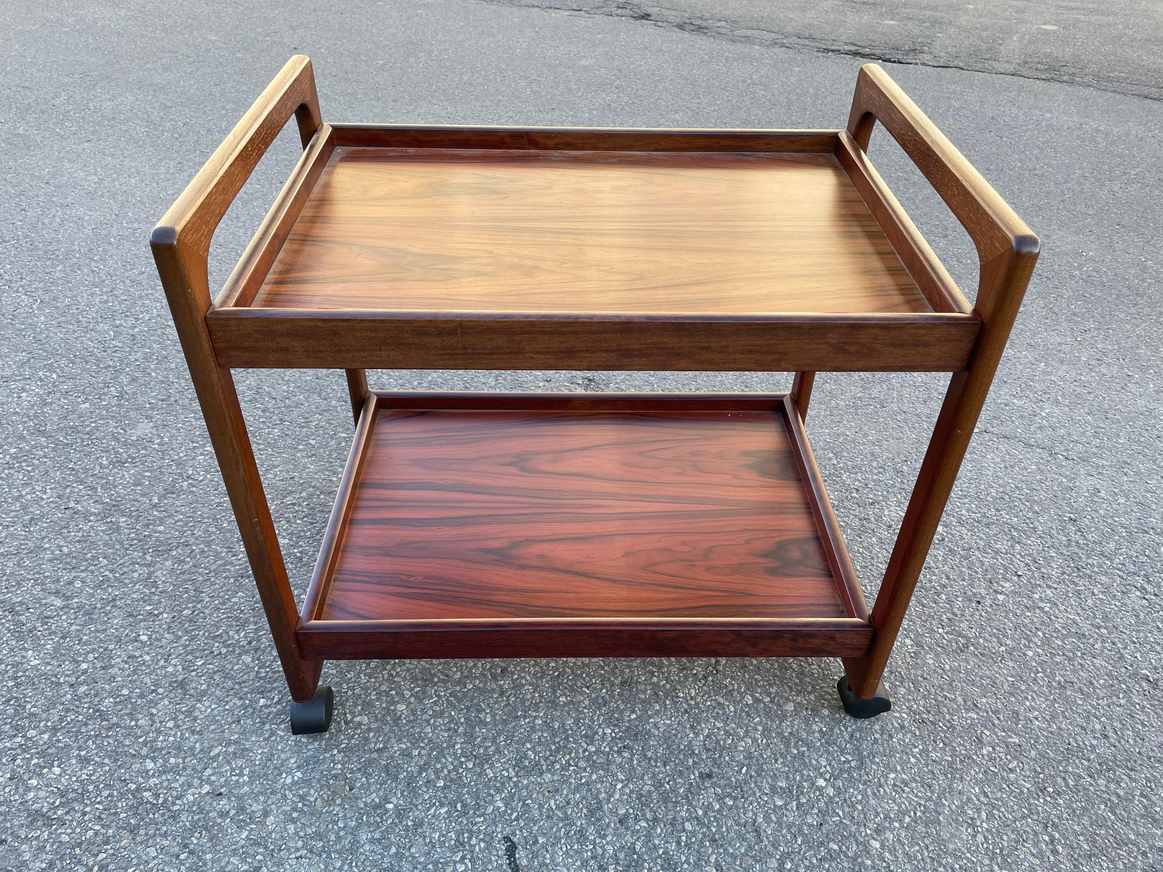 Midcentury Danish modern rosewood bar cart in excellent condition. The cart features gorgeous rosewood and Minimalist Danish design.