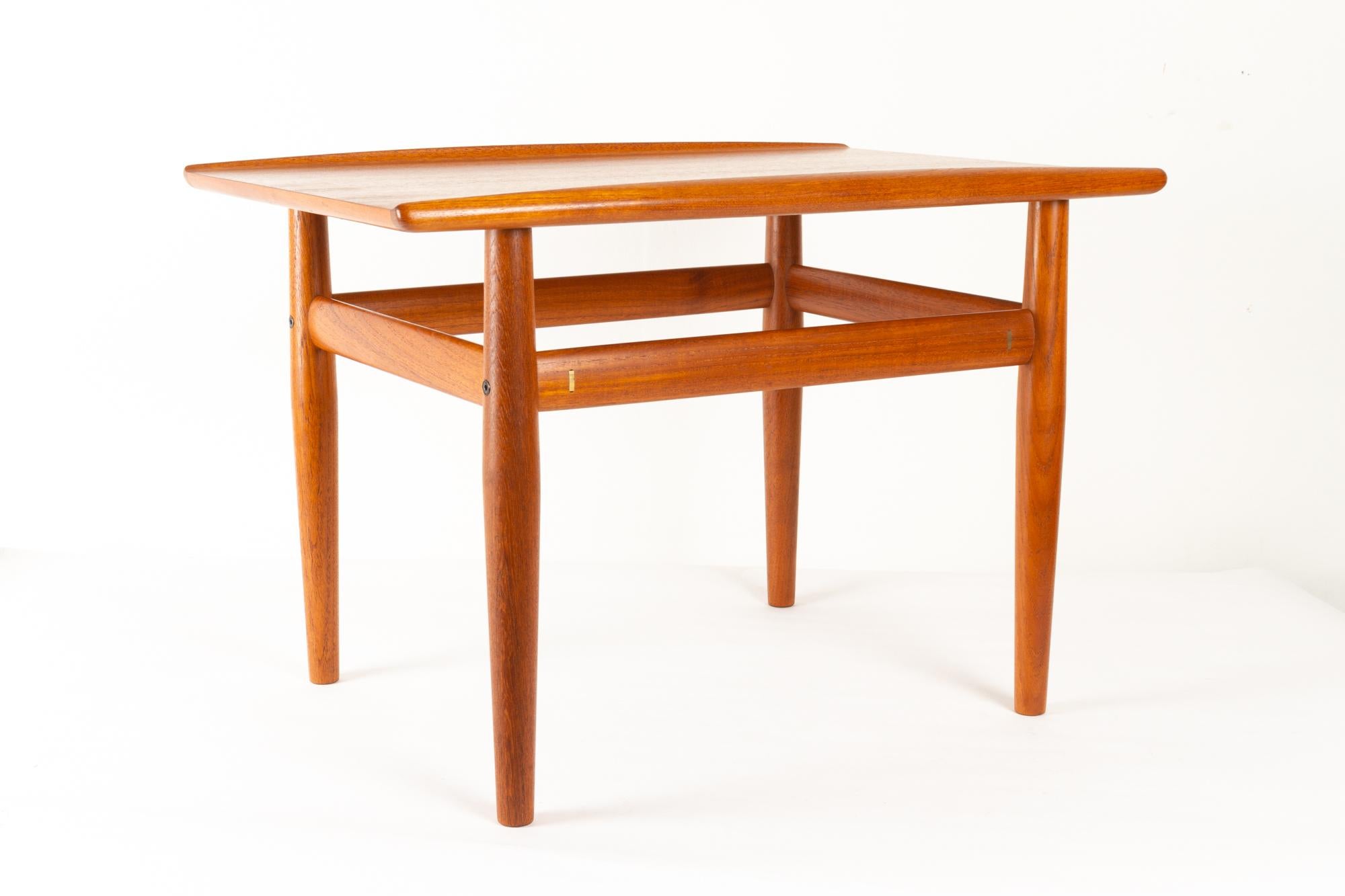Vintage Danish teak side table by Grete Jalk for Glostrup Møbelfabrik, 1960s
Danish modern small coffee table with round tapered legs and frame in solid teak. Tabletop in teak veneer with raised edges also in solid teak. 
Elegant and decorative