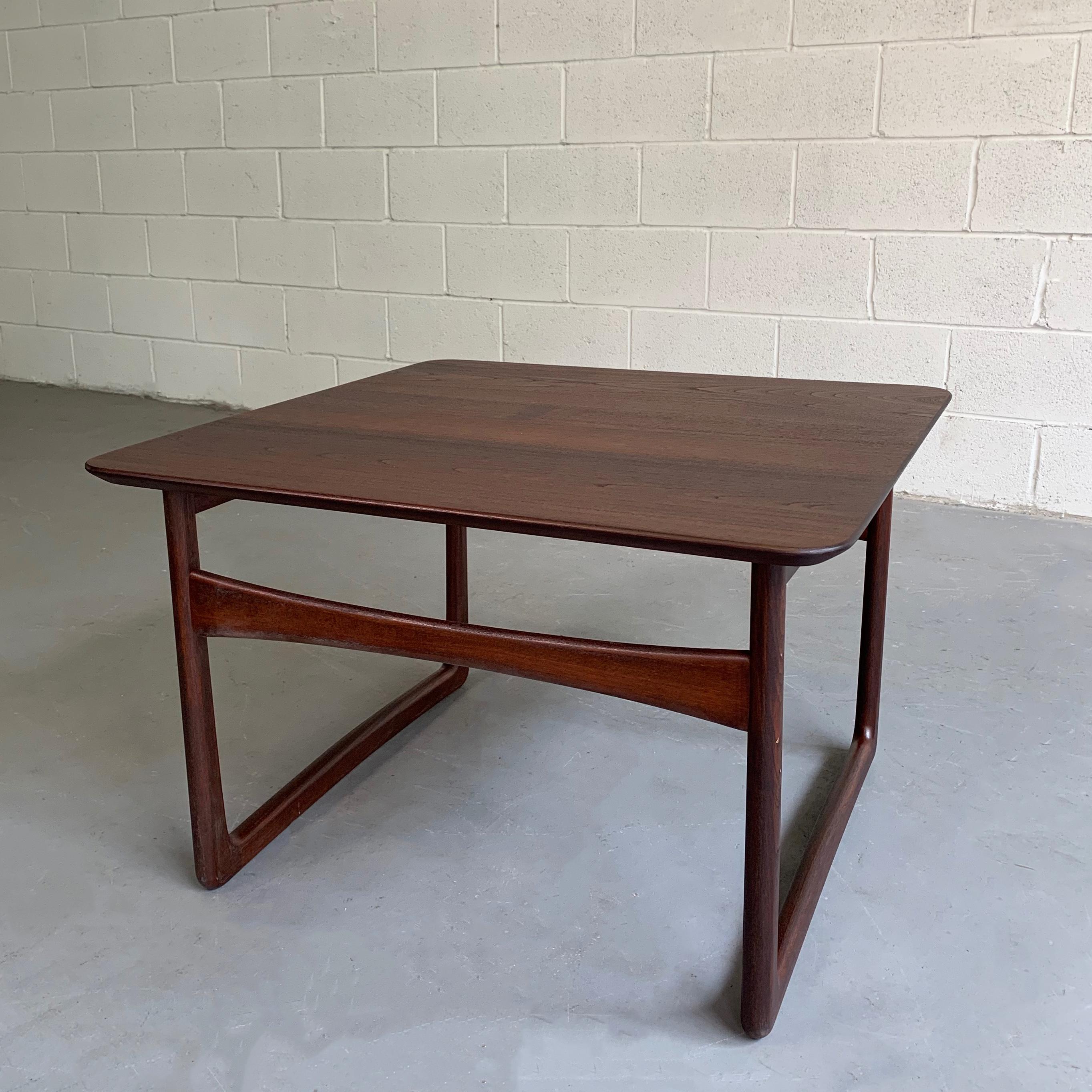 Elegant, Mid-Century Modern, dark teak, side table by Peter Hvidt & Orla Mølgaard-Nielsen sold by John Stuart features sleigh legs that are interesting from all angles. Two tables are available, the other in a medium teak finish is listed separately.