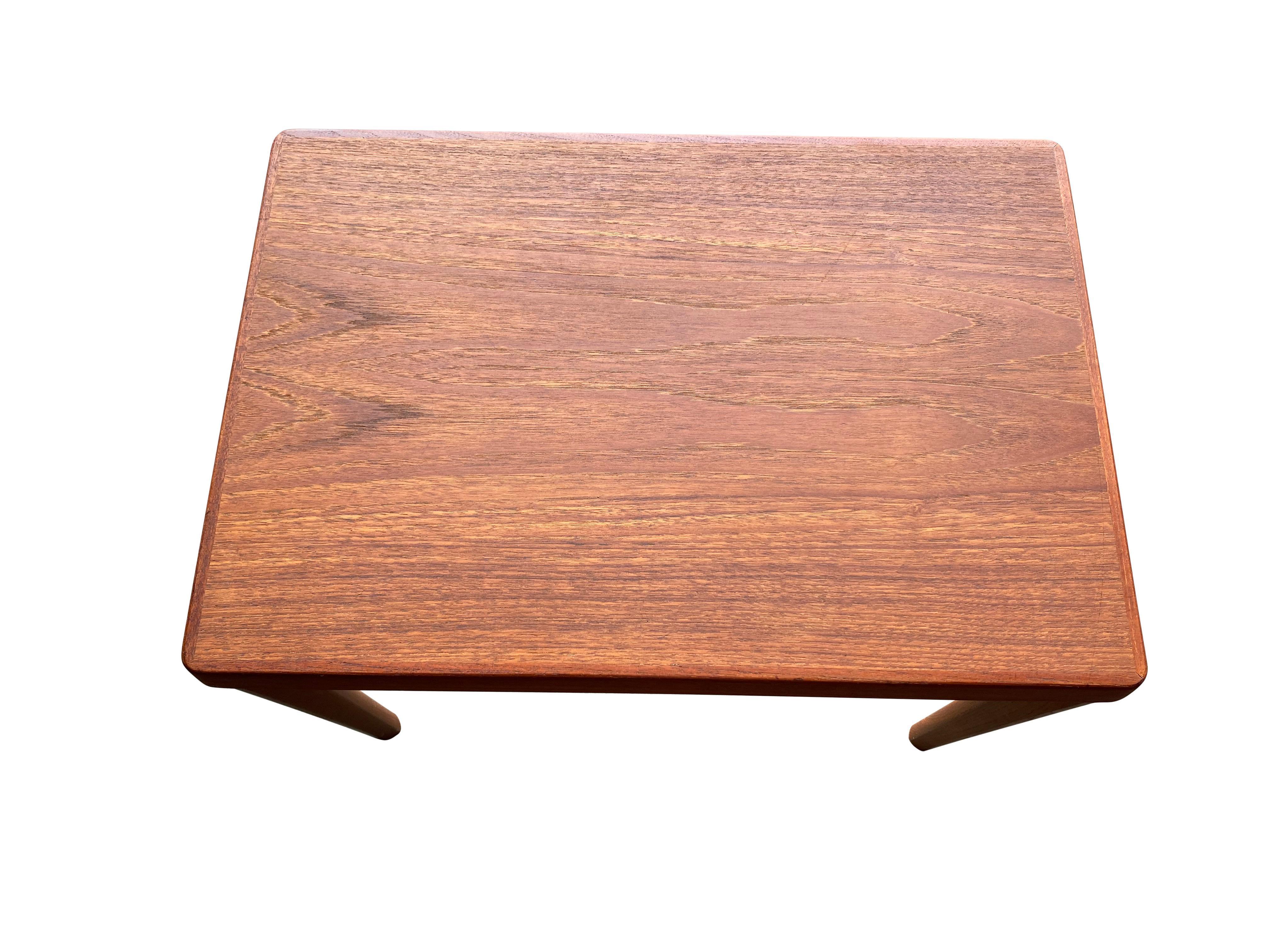 Elegant Danish modern side table executed in teak. Warm tones and attractive grains. Stamped Vejle Stole Møbelfabrik. Perfect for use as a nightstand or next to a sofa. Plenty of room for a lamp, vase, books, and a cup of coffee. In good condition