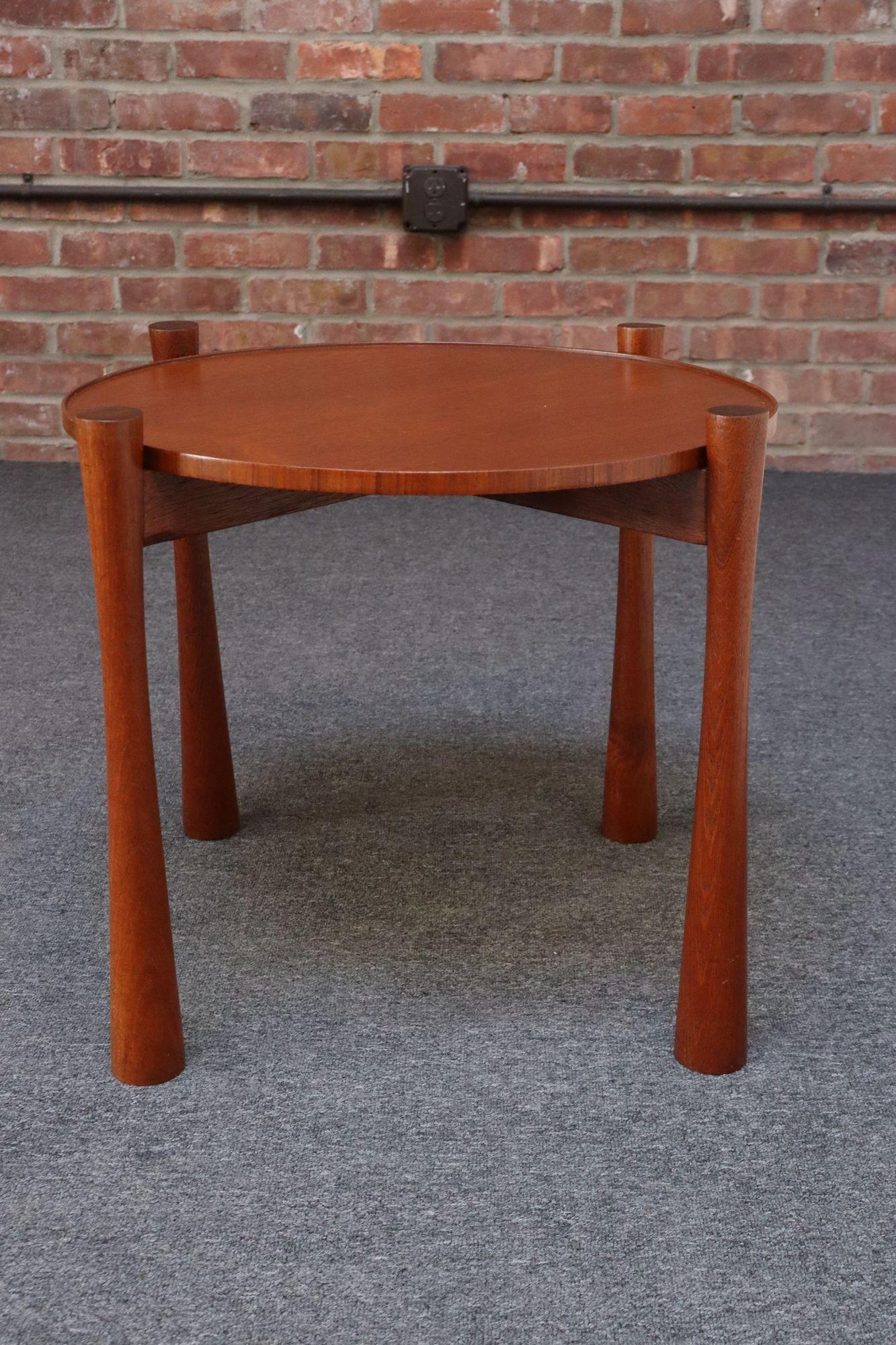 Table d'appoint vintage en teck (ca. 1960s, Danemark).
Composé d'une base en teck dotée de pieds denses et profondément sculptés supportant un plateau amovible, une commodité qui simplifie le passage de la préparation au service lors des