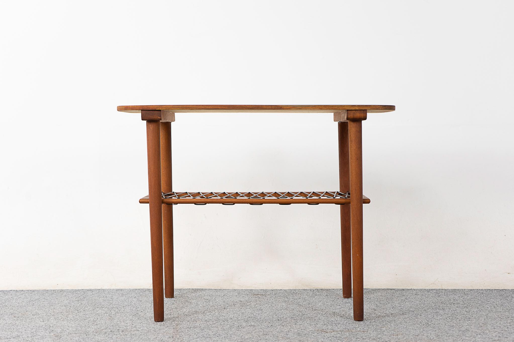 Teak Danish side table, circa 1960's. Lovely rounded rectangle with beautiful warm tone graining patterning. Unique airy woven shelf. Compact, highly functional table work great with lounge chairs or loveseats. 