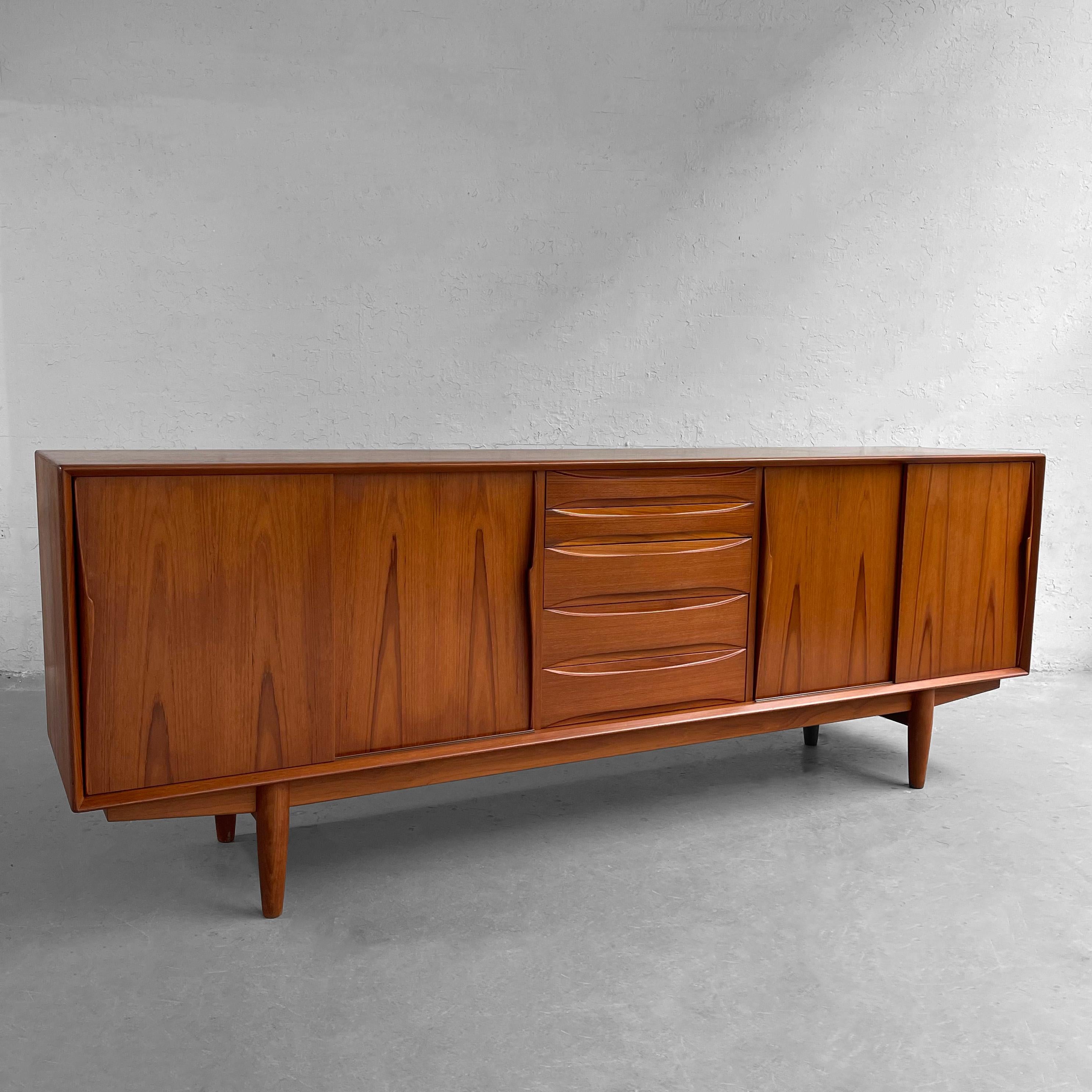 Wonderfully detailed, classic, Scandinavian modern, teak credenza, sideboard by Dyrlund features center drawers with deocrative, recessed pulls and sliding door cabinet storage on either side with adjustable interior shelves.
 