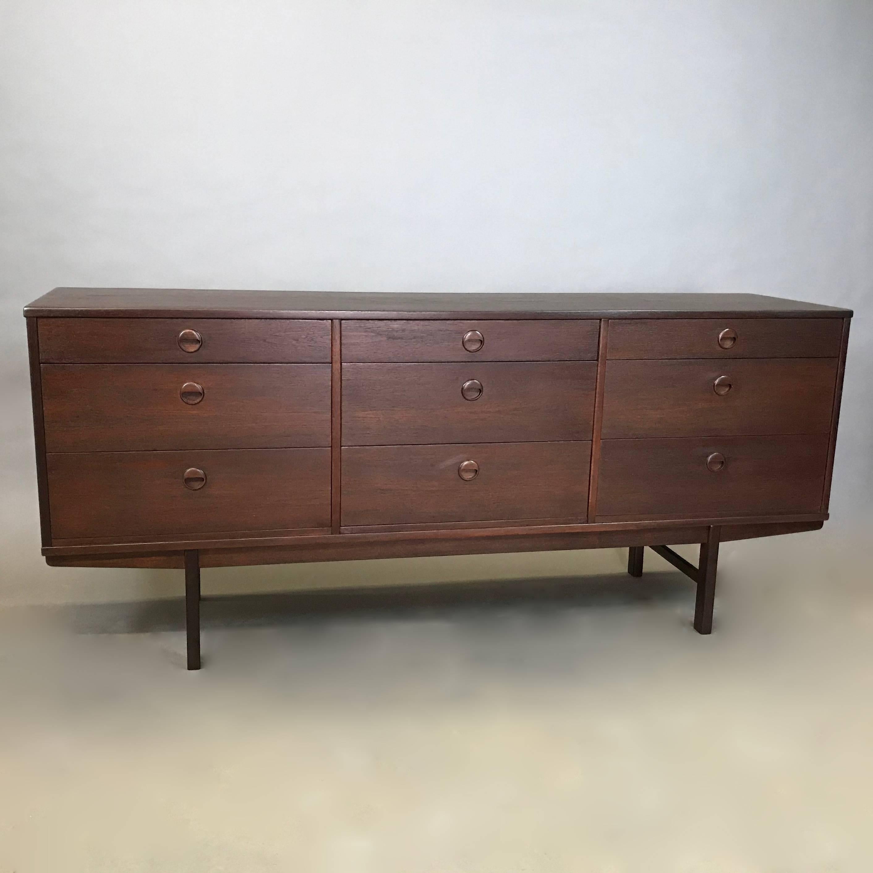 Danish modern, credenza, sideboard by Folke Ohlsson for DUX features his signature recessed pulls on it's nine drawers and is newly restored in a stunning dark teak finish. The top left drawer is divided and felt lined for silverware but this