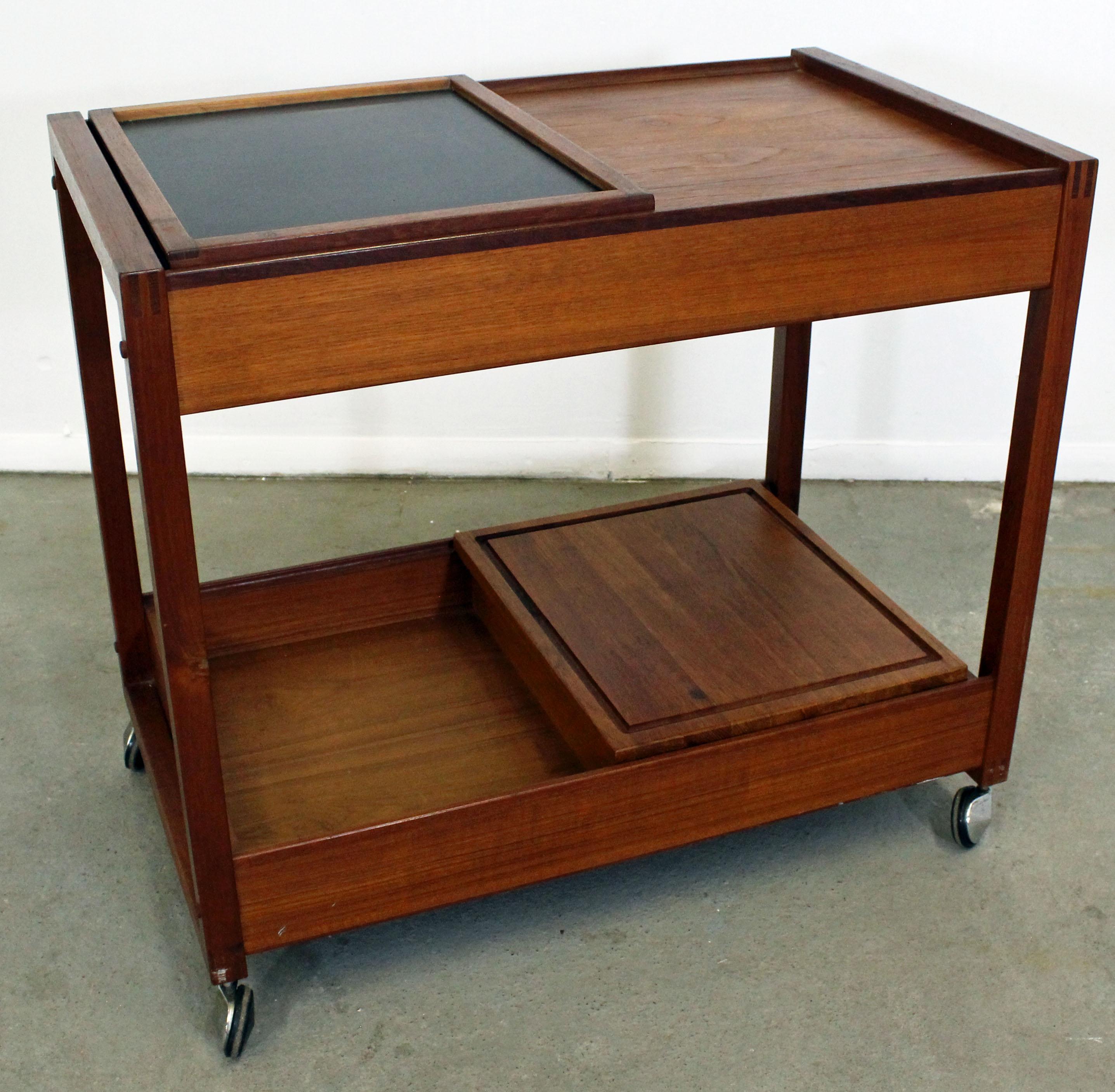 What a find. Offered is a very cool Danish modern teak bar cart. Features two sliding doors on top and bottom with compartments. It is also on wheels. Great for storage, serving drinks or food. It is in excellent condition, showing some age wear. It