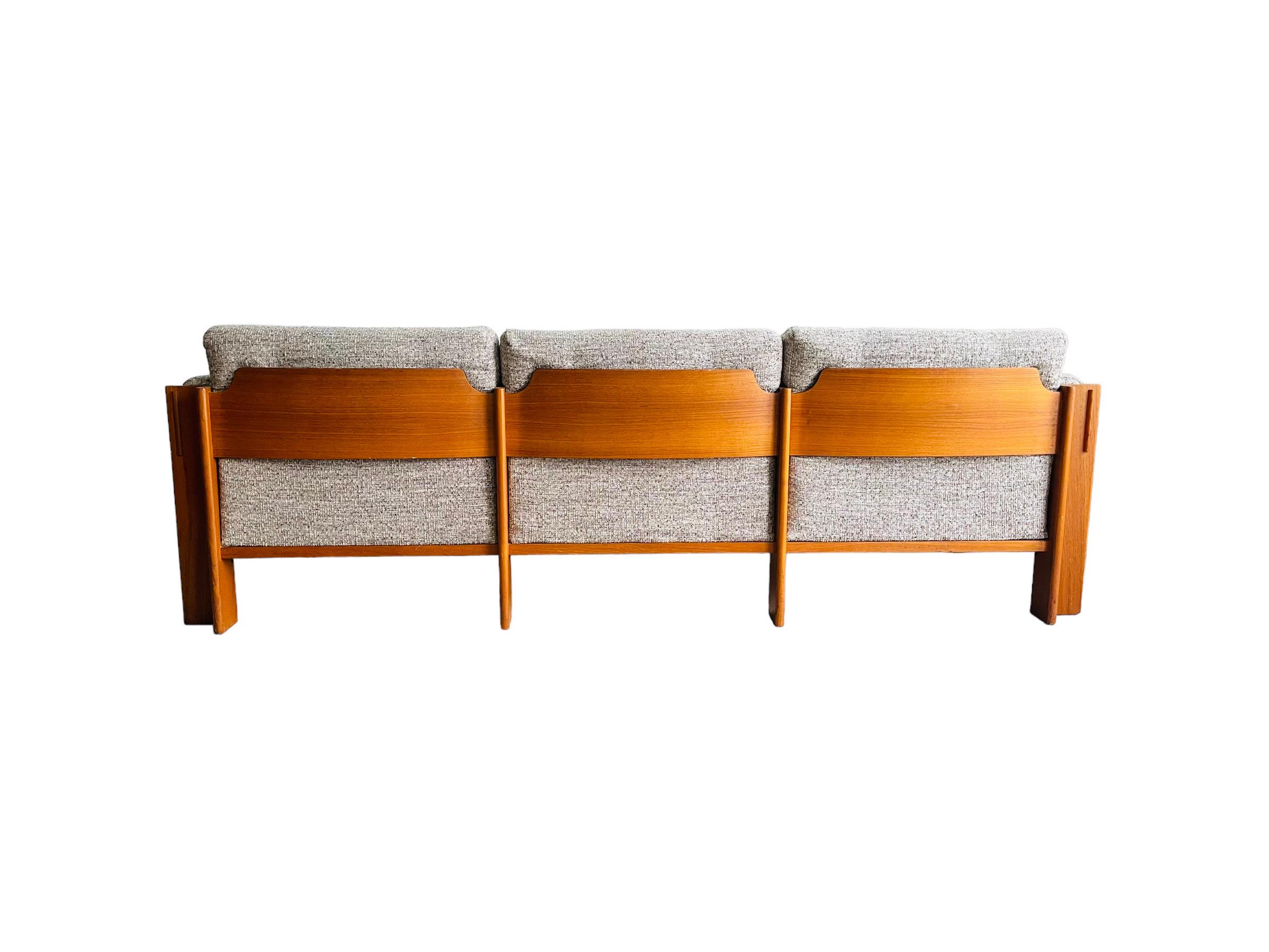 Introducing the midcentury Danish Modern Teak Sofa by JYDSK MOHOLVAERK, the epitome of timeless sophistication and comfort. This gorgeous sofa boasts a sleek teak frame that is not only sturdy and durable but also adds a touch of elegance to any