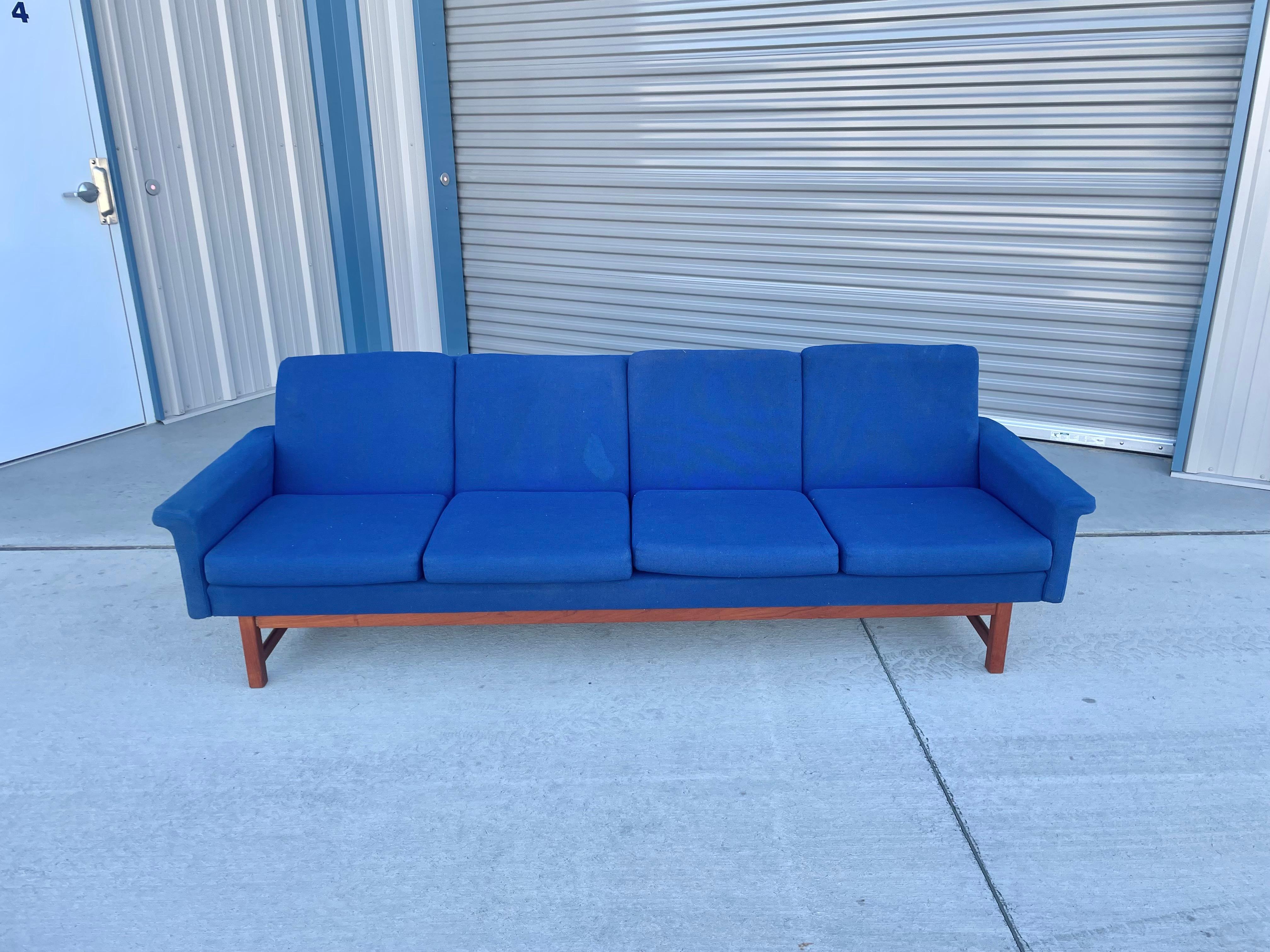 Danish modern teak sofa was designed and manufactured in Denmark circa 1960s. This beautiful sofa is covered in blue fabric upholstery on a teak frame that provides optimal comfort and style to add a modern flair to your home space.