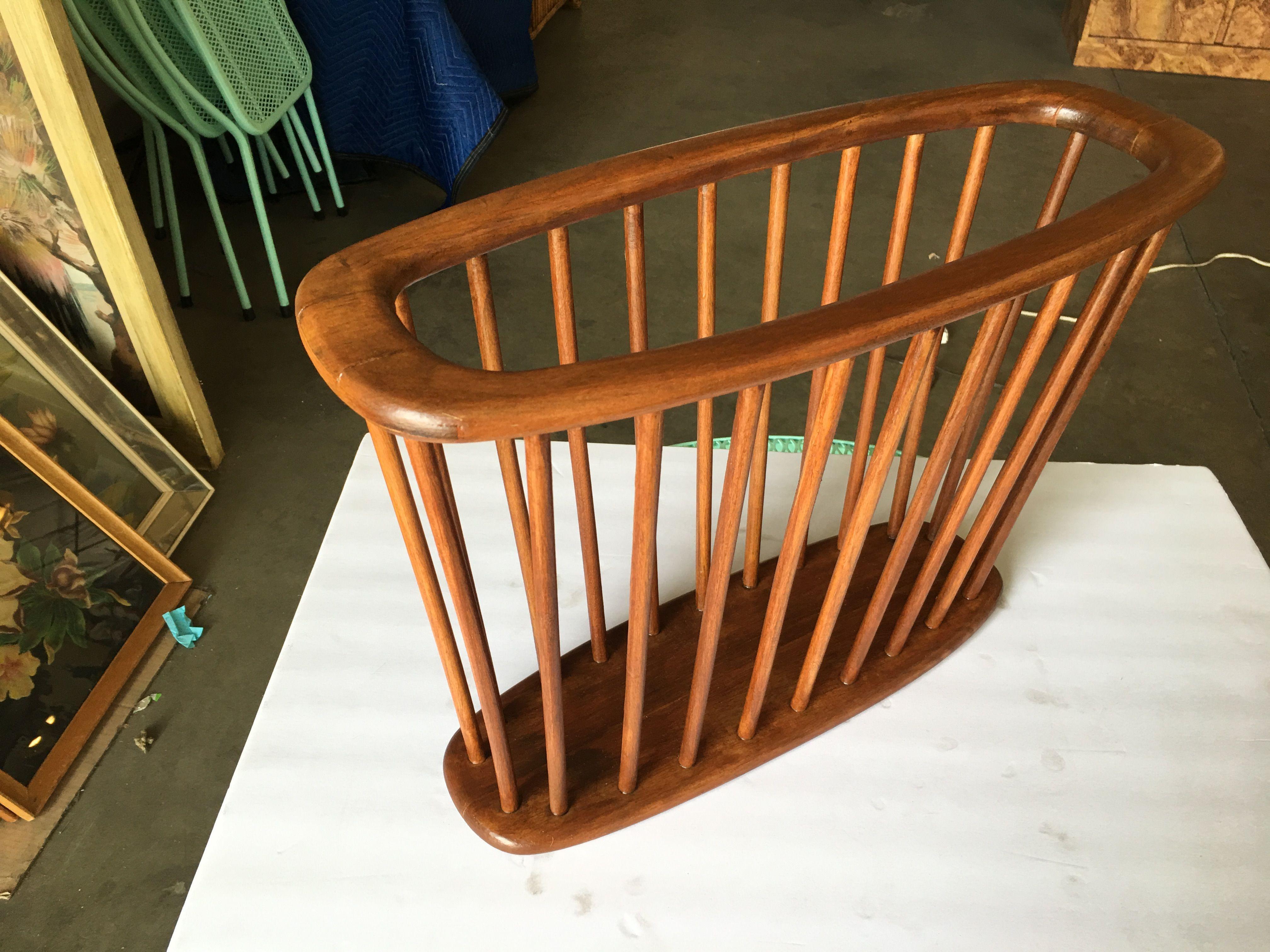 Vintage 1960 Danish Mid Century Modern teak spindle magazine rack by Arthur Umanoff featuring a wide oval top held up by a spindle form.