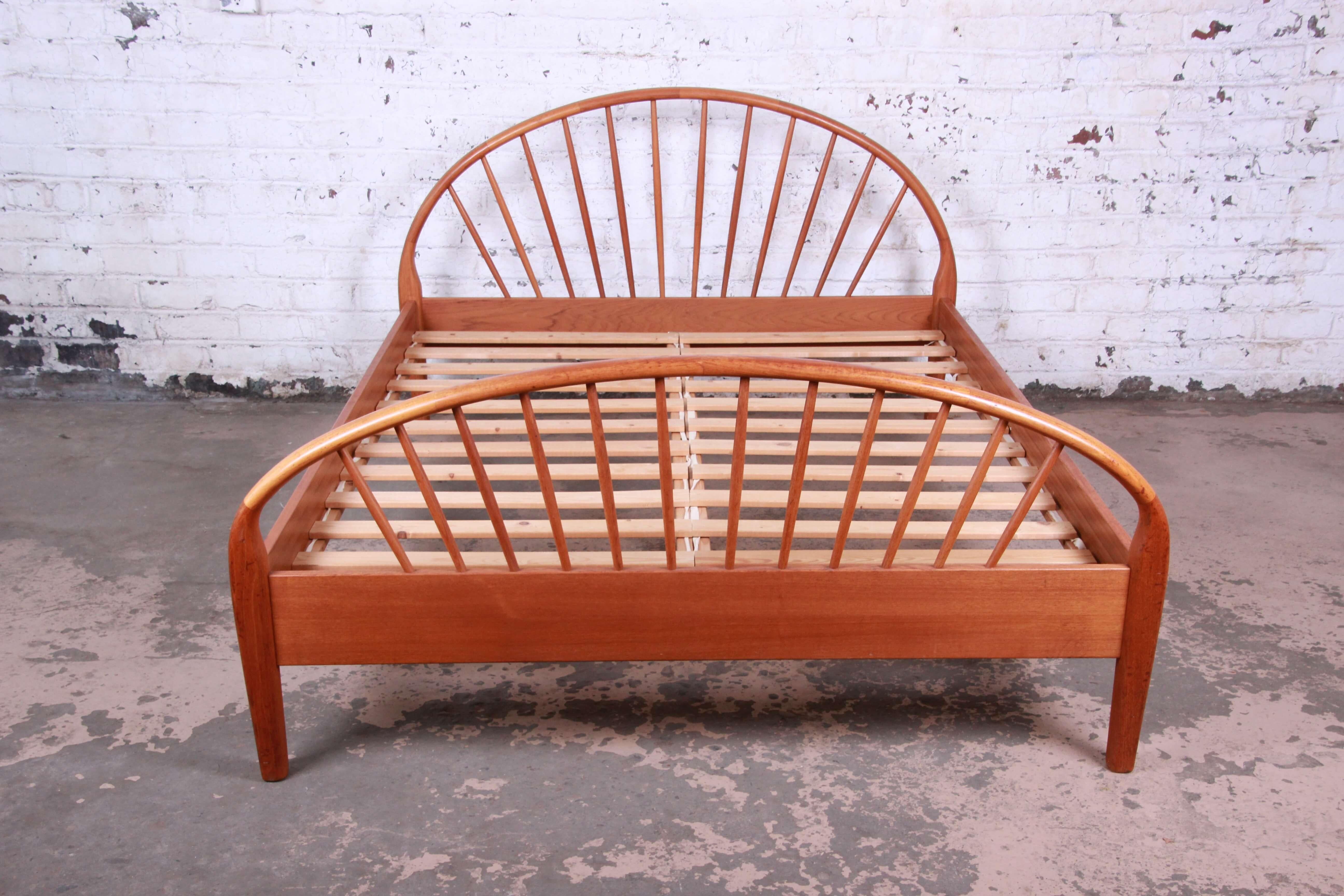 Offering a very nice and unique vintage queen size Danish Modern teak bed by Jesper. The bed has a nice solid teak wood frame with curved headboard and footboard with spindle design. The bed comes with all original hardware and slats. It is made by