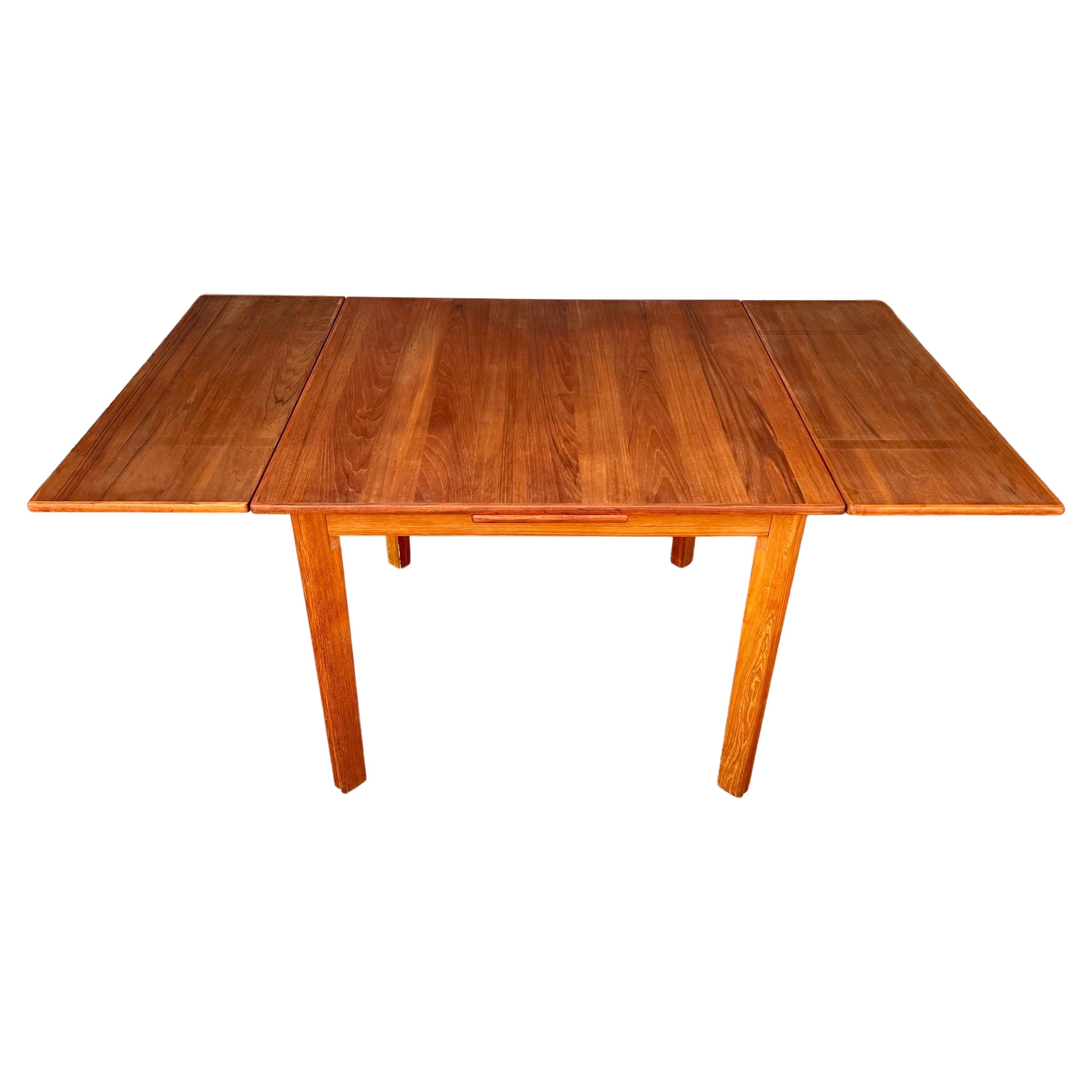 Versatile square Danish modern teak dining table, with 2 leaves that hide under the top, as shown nice solid teak legs freshly refinished, nice solid and sturdy the legs come off for easy shipping. The table its 38