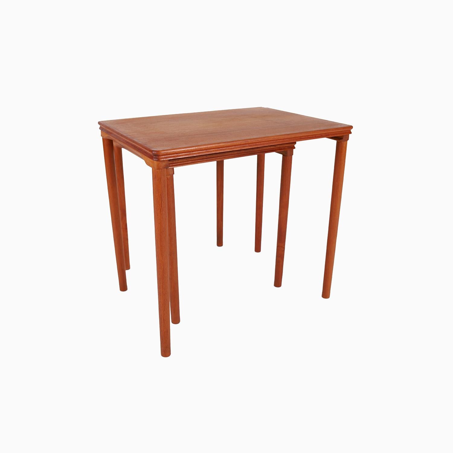 
Ein Satz von zwei Nisttischen aus altem Teakholz mit einer doppelt abgeschrägten Kante und schlanken, gedrechselten, konischen Beinen mit einem modernistischen 
