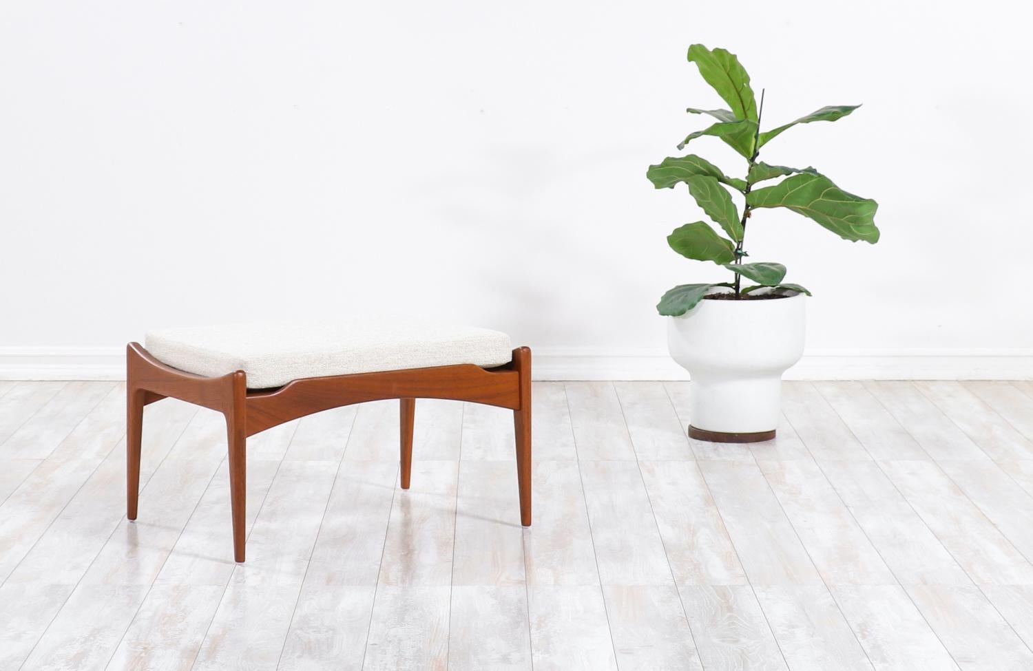 Classic sculptural stool designed by Poul Jensen, in collaboration with the Danish / American company Selig, in the 1960s. This beautifully designed modern stool features a sculpted teak frame that supports its comfortable new high-density foam