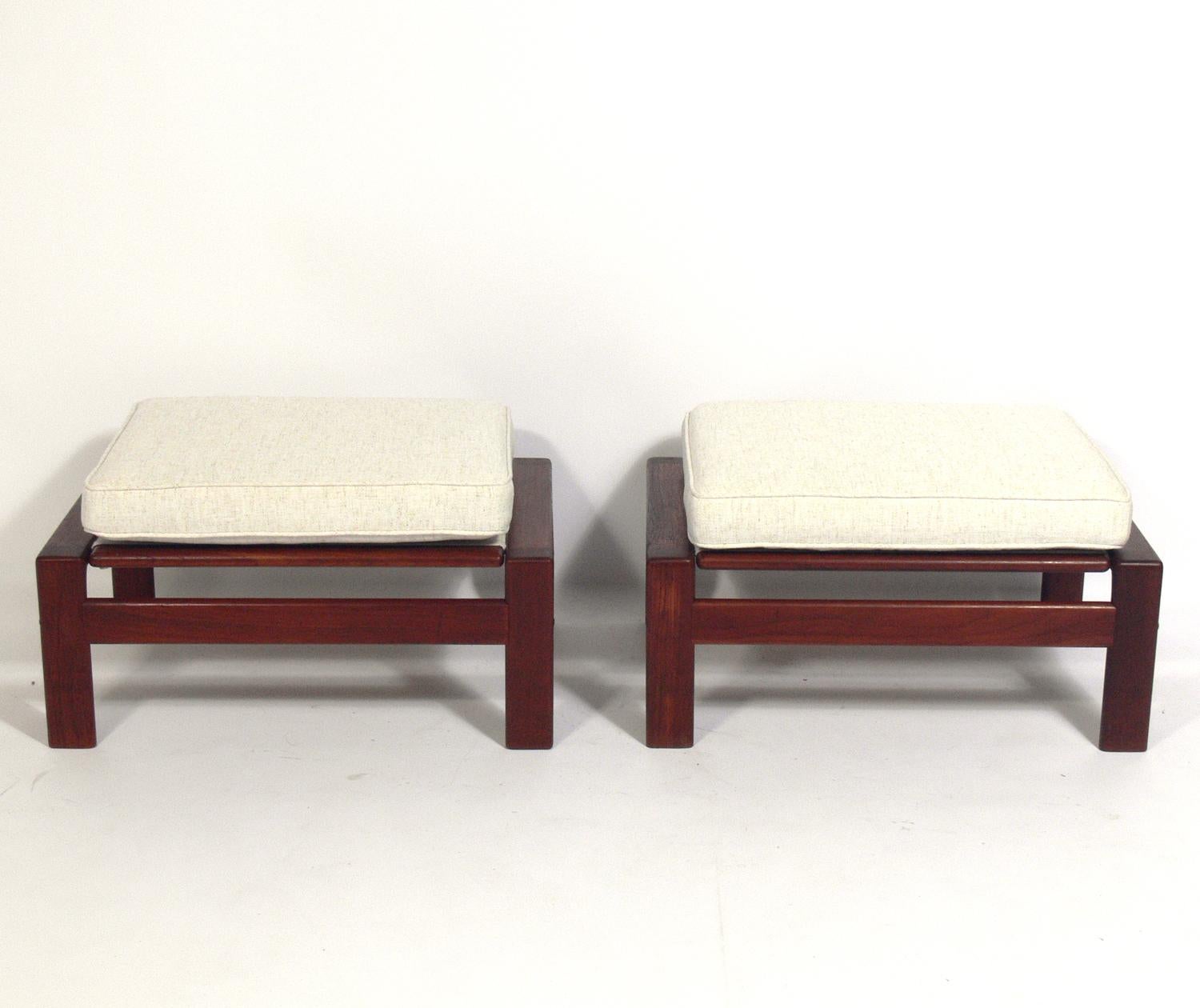 Danish modern teak stools or ottomans, made by Komfort, Denmark, circa 1960s. They have been recently reupholstered in an ivory herringbone fabric. The teak frames have been cleaned and Danish oiled.