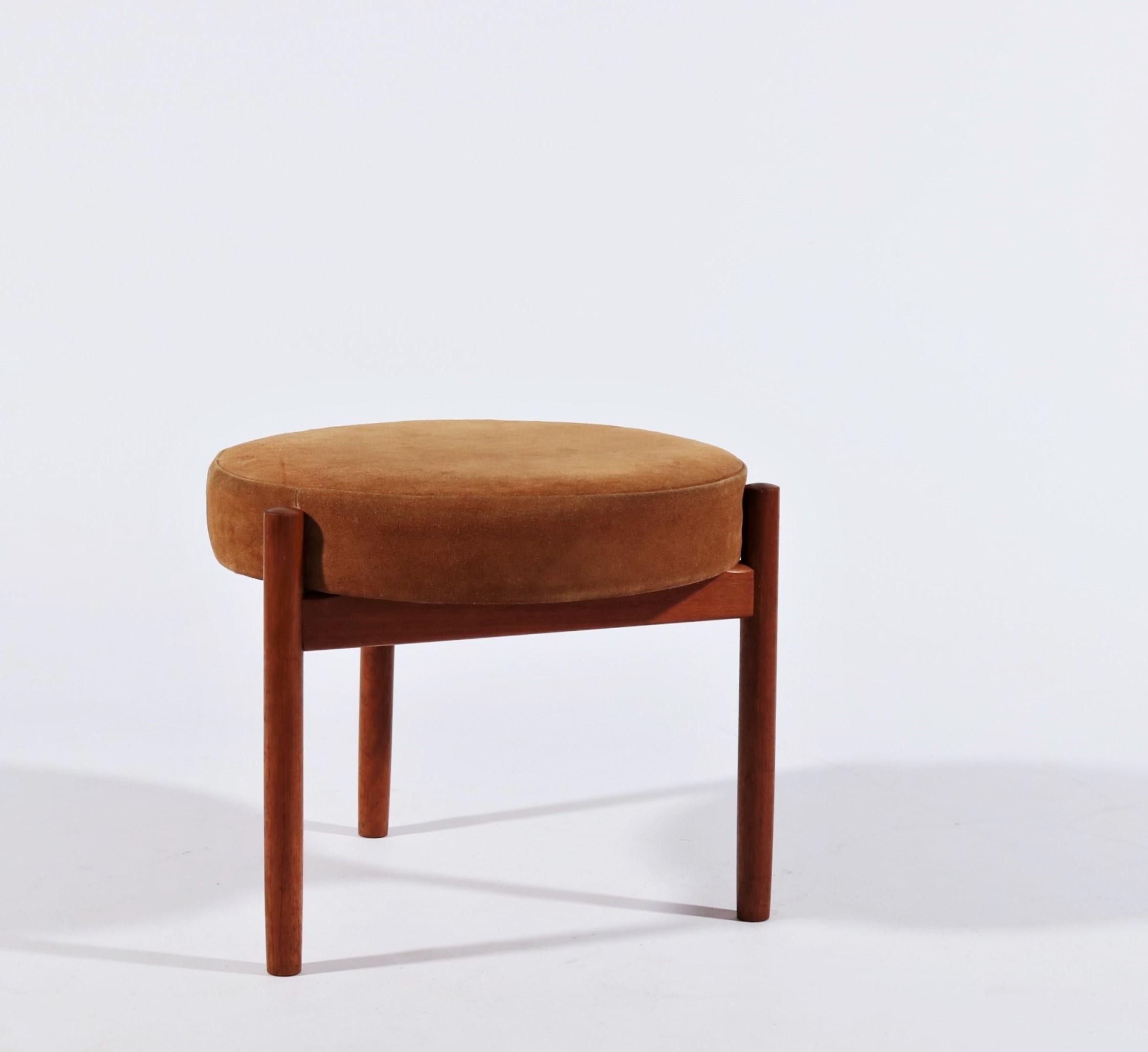 Elegant three-legged stool or ottoman designed by Hugo Frandsen for Spottrup, Denmark in 1965. The stool has a teak wood frame and seat cushion with original burnt orange / brown suede upholstery in good vintage condition. Stamped with makers mark