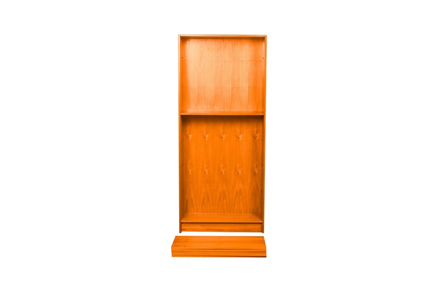 An exceptional teak tall bookcase from Denmark. Gorgeous Mid-Century Modern Teak bookcase / tall bookshelf unit. Beautiful, minimalist, clean, straight lines, features Hidden metal shelf hangers with 6 shelves: 5 adjustable, one fixed for various