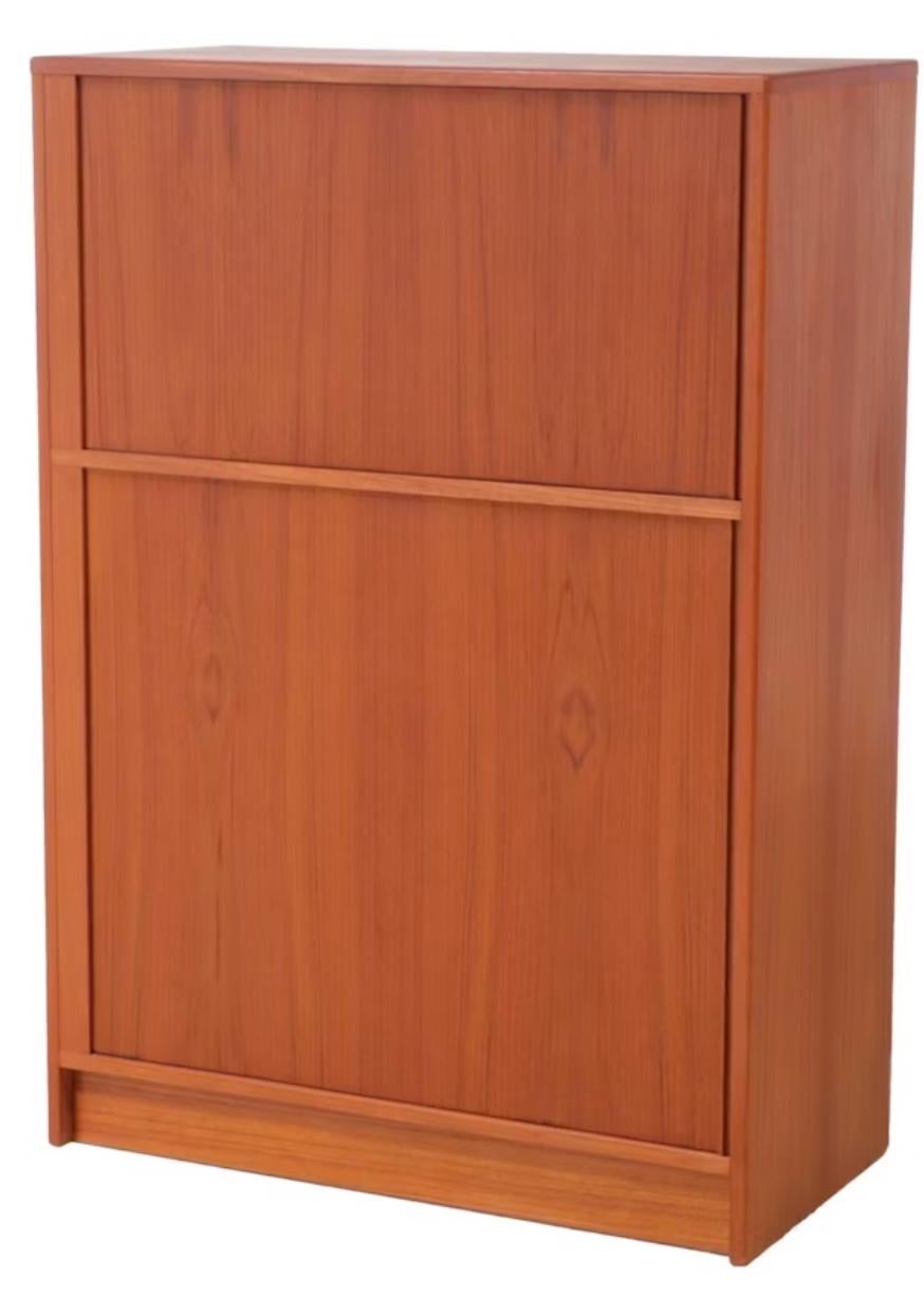 Pulita e spaziosa pressa per biancheria con ante a tamburo in teak o cassapanca alta. C'è una sezione superiore e una inferiore con più cassetti. Sette scomparti e quattro cassetti. Ottima scelta per le camere da letto più piccole. 