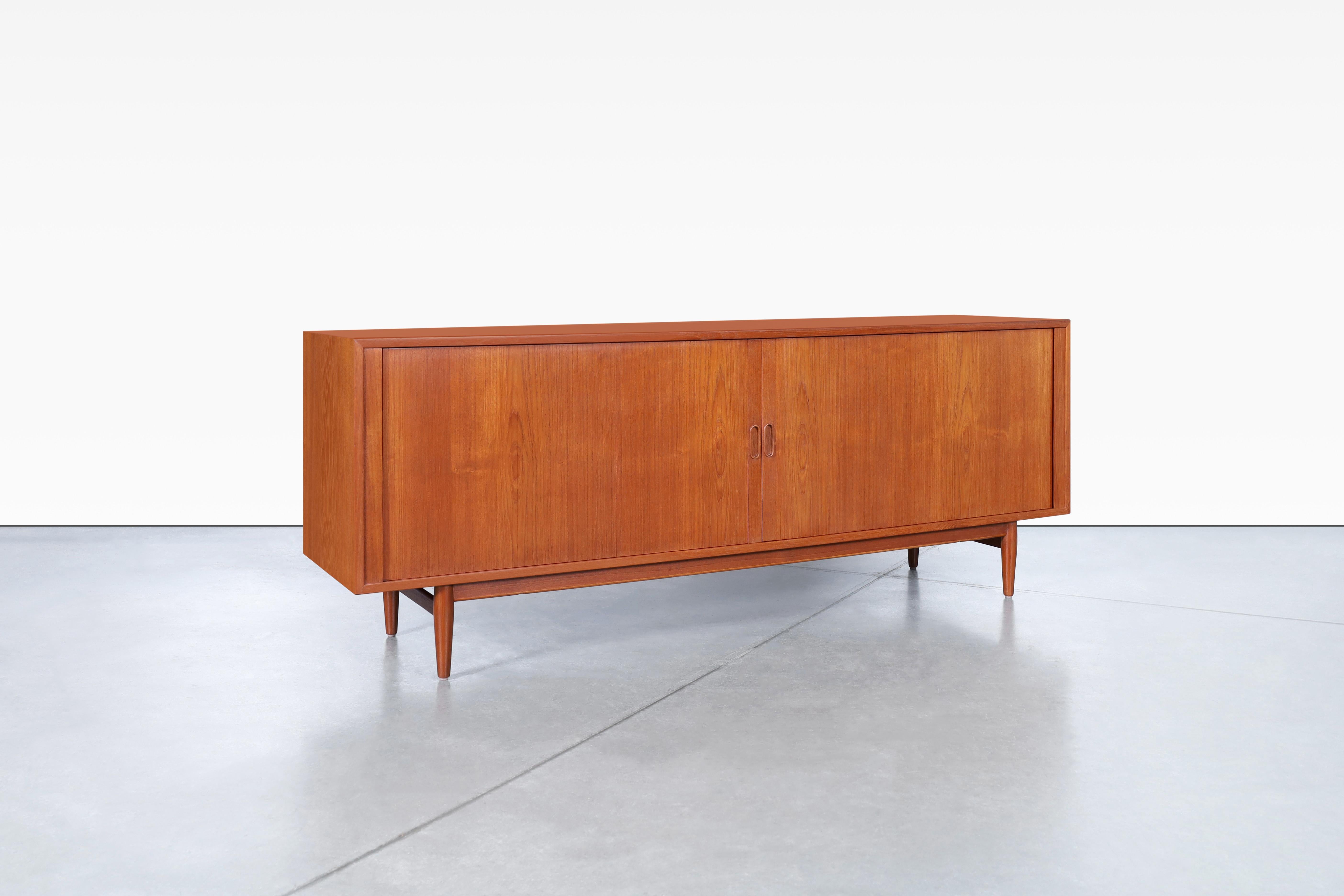 Danish modern teak tambour door credenza designed by Arne Vodder for Sibast in Denmark, circa 1950s. This teak sideboard, also known as model #37, is a masterpiece of Danish furniture design. The impeccable craftsmanship is evident in every detail,