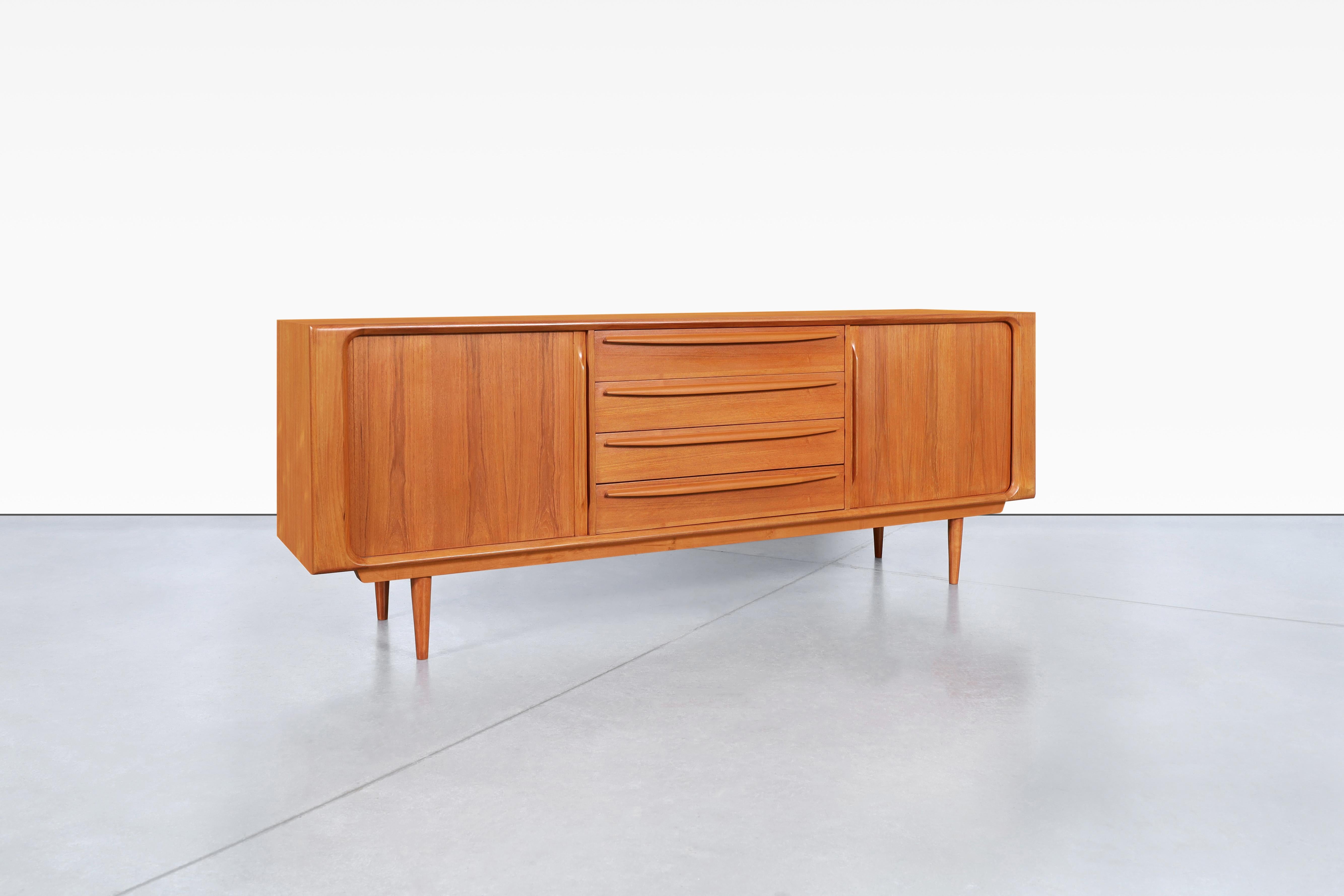 Questa credenza moderna danese con ante a tamburo in teak è uno splendido esempio di design di metà secolo. Realizzato da Bernhard Pedersen & Son in Danimarca negli anni '60, questo pezzo emana eleganza e funzionalità. Al centro sono presenti