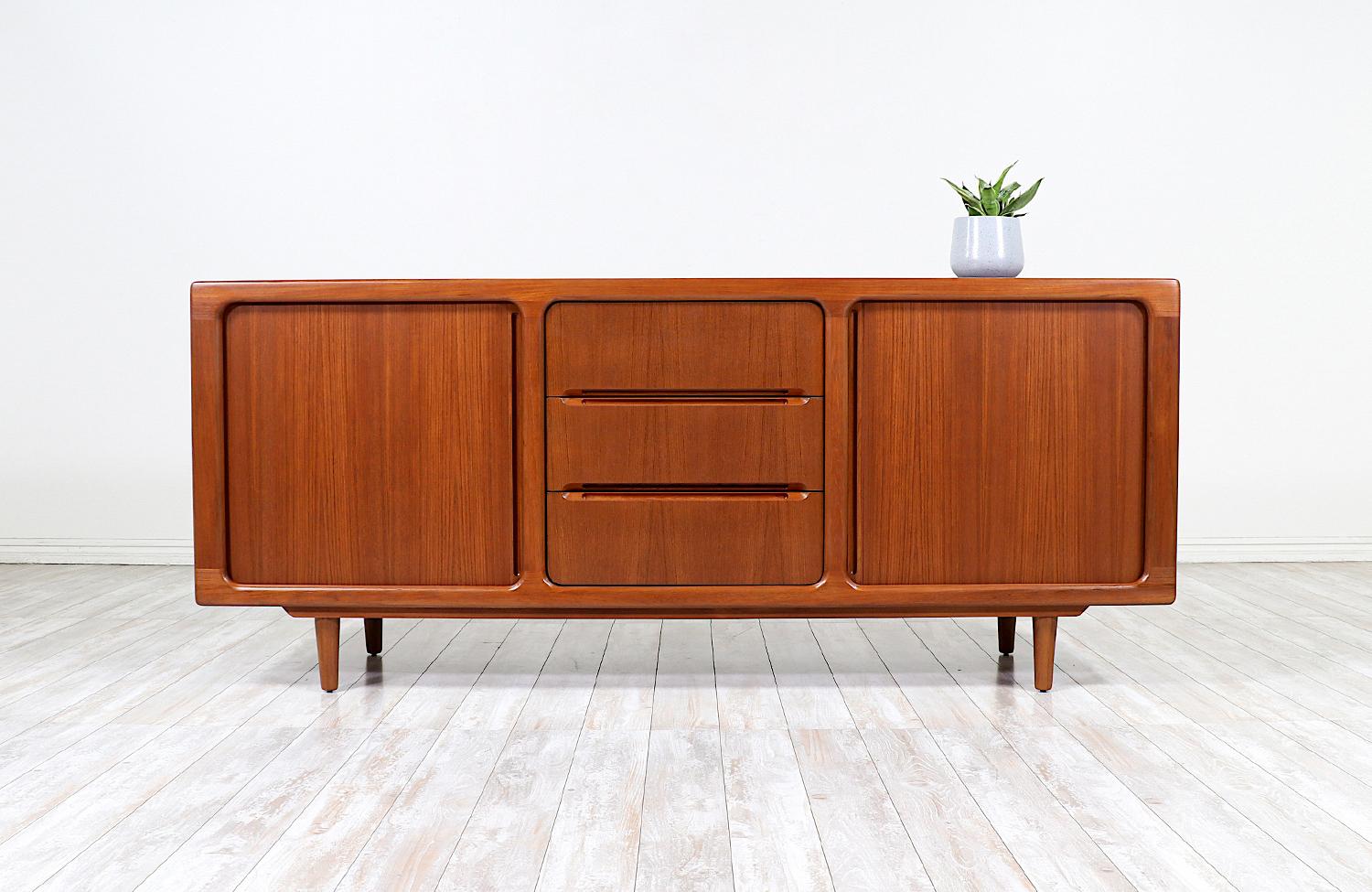 Danish Modern tambour-door credenza designed and manufactured by Dyrlund in Denmark in the 1960s. This classic Danish Modern and functional design features a solid teak wood frame with tapered legs and gorgeous tambour doors with carved handles. The