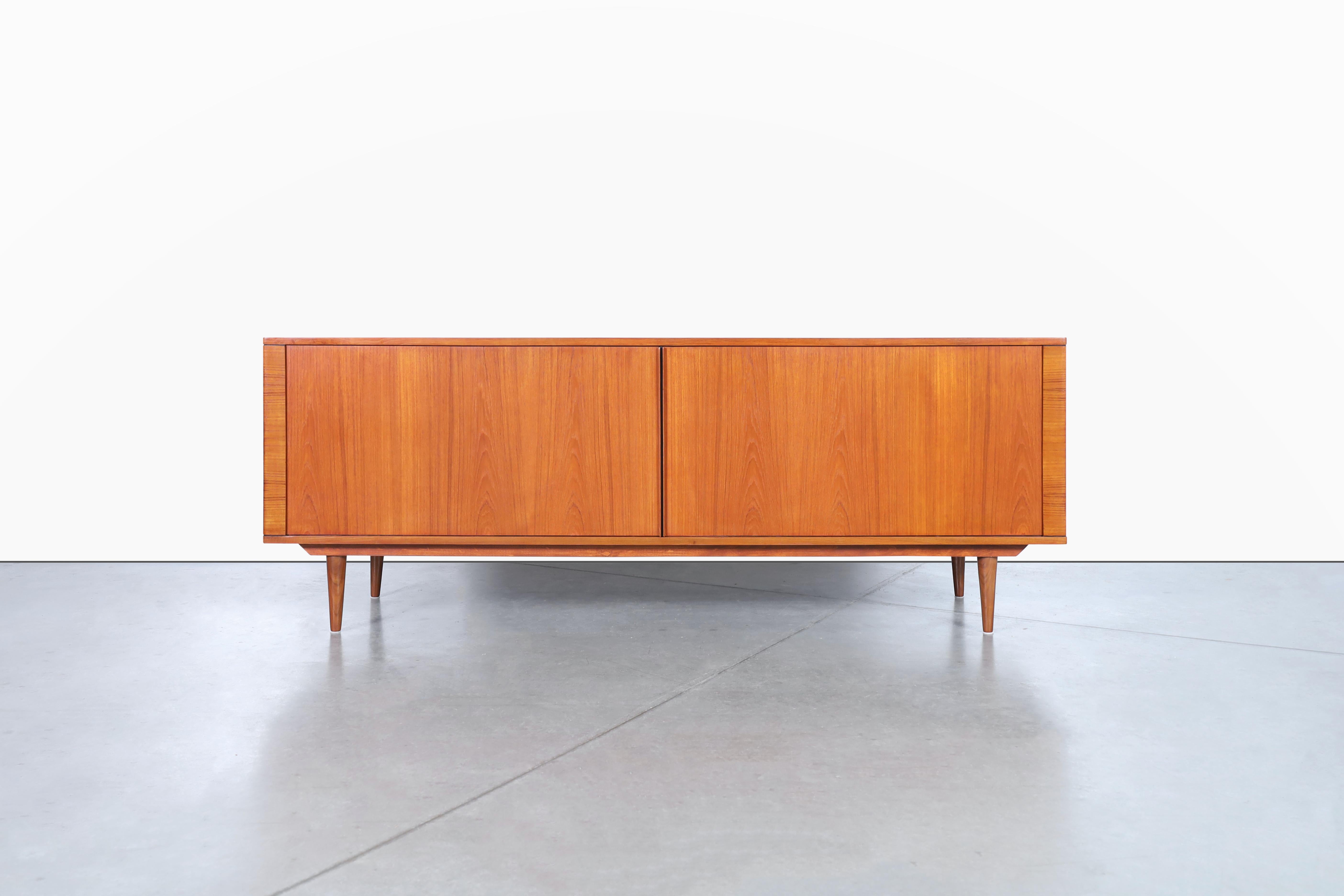 Questa credenza moderna danese con anta a tamburo di Hornslet Mobelfabrik, Danimarca, risalente agli anni '70, è un mobile di sicuro effetto. La credenza è dotata di due ante a battente che scorrono agevolmente, consentendo un facile accesso