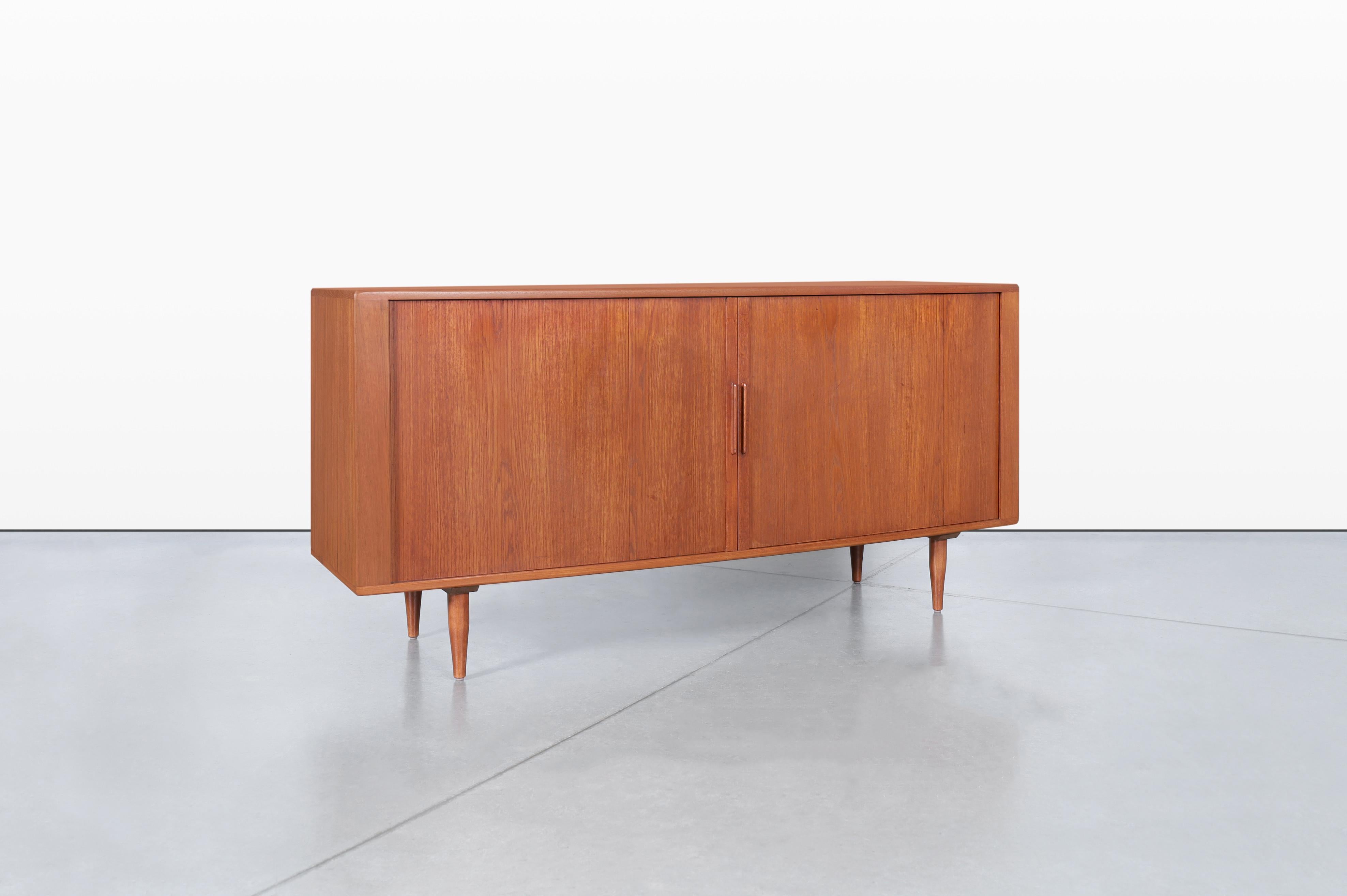 Questa splendida credenza moderna di metà secolo, realizzata da H. & A. Hansen, realizzato in Danimarca negli anni '60, è un mix perfetto di funzionalità e design elegante. Caratterizzato da due grandi ante a battente con maniglie finemente